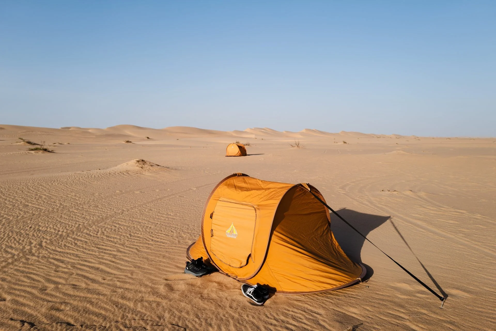 Pop-up tents on Empty Quarter sand dunes at sunrise during Evolving Cities desert shoot