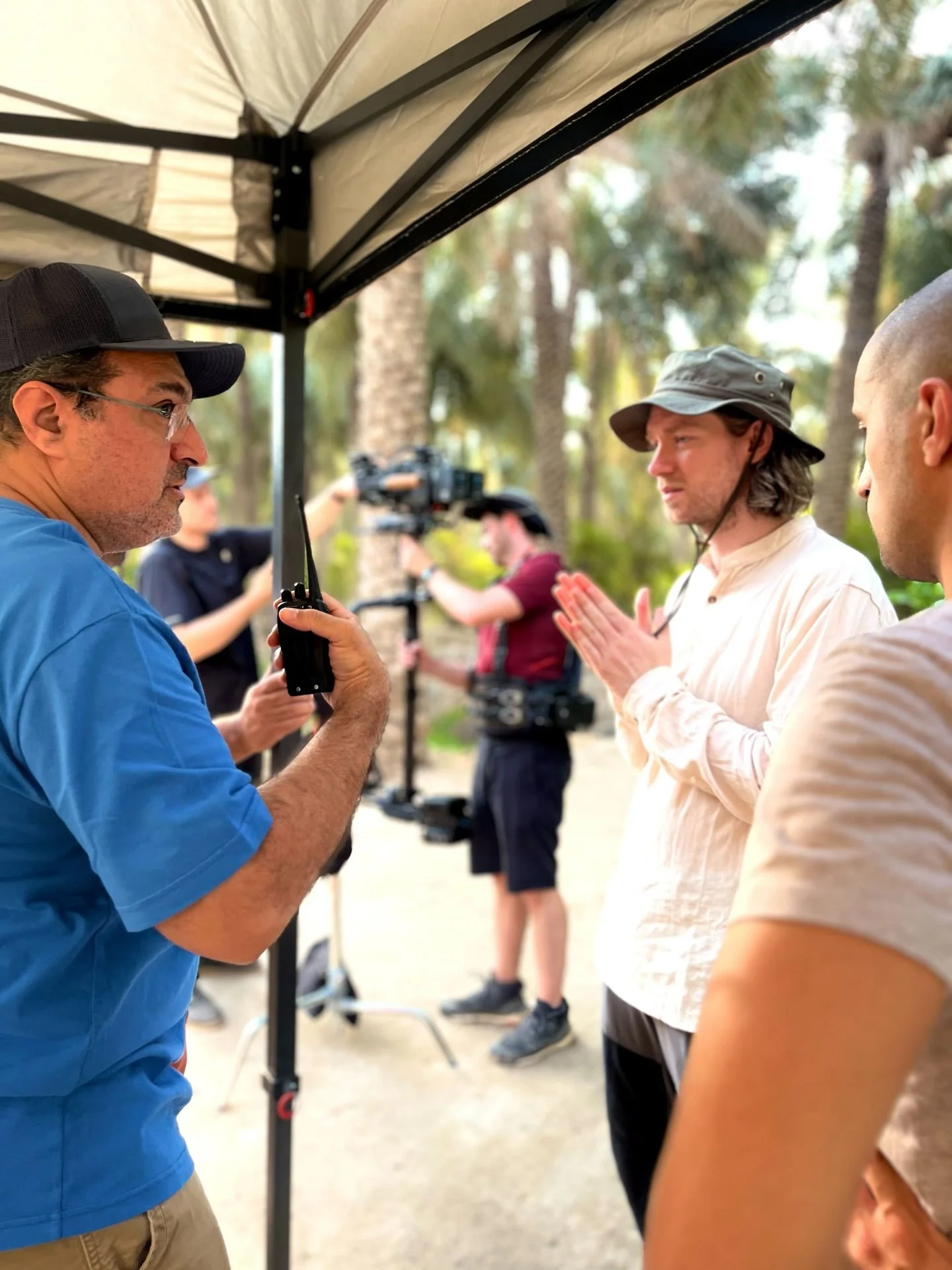Director James Dougan briefing crew under shade at Al-Ahsa Oasis during Evolving Cities production