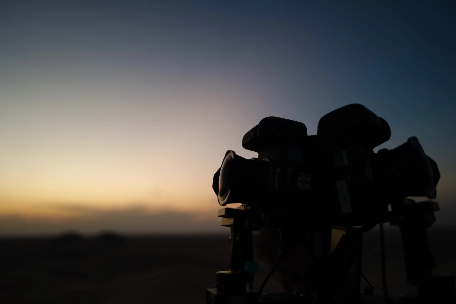 Cinema camera silhouette against desert sunset during Evolving Cities golden hour filming