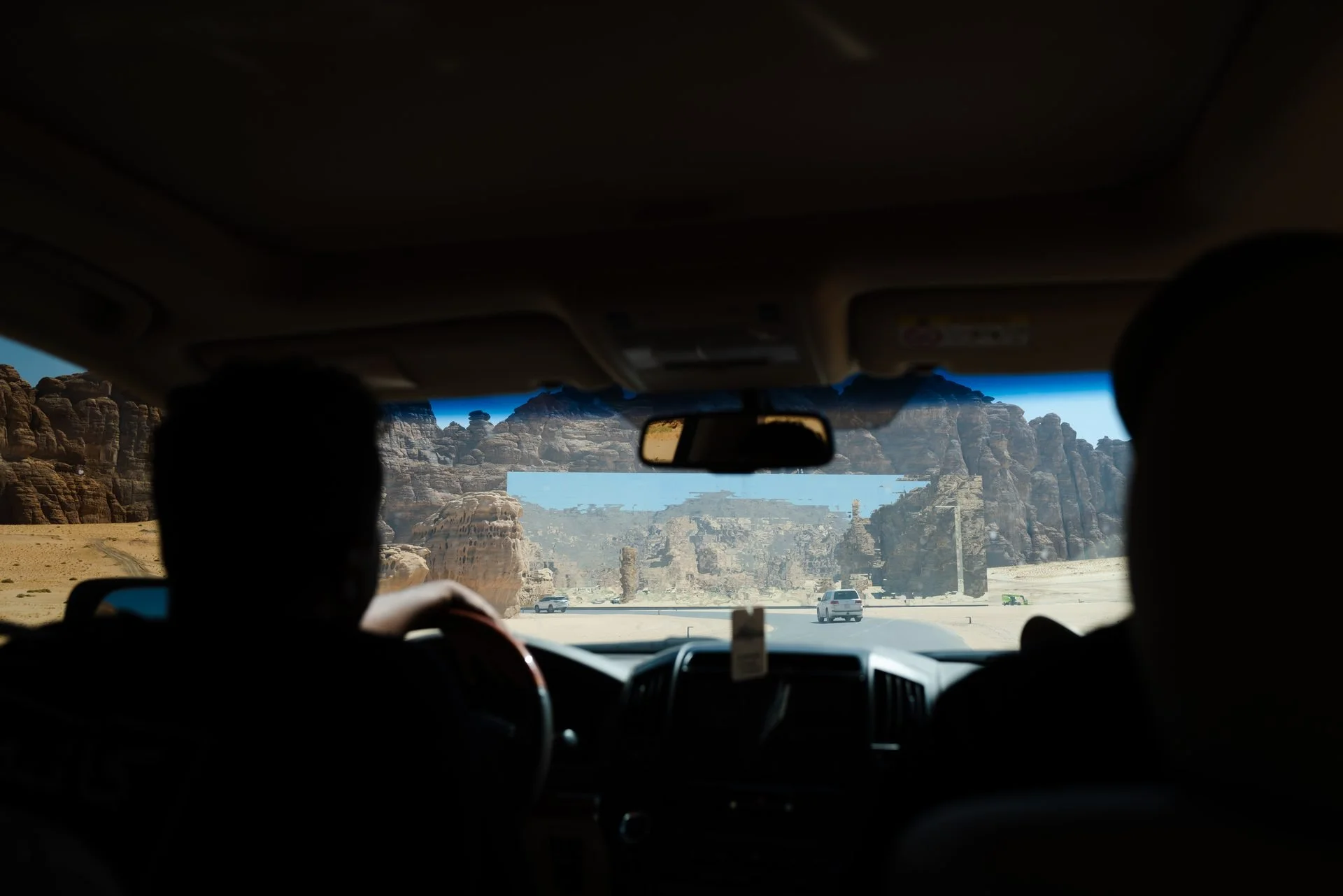 Crew driving through AlUla sandstone canyon formations during Evolving Cities production