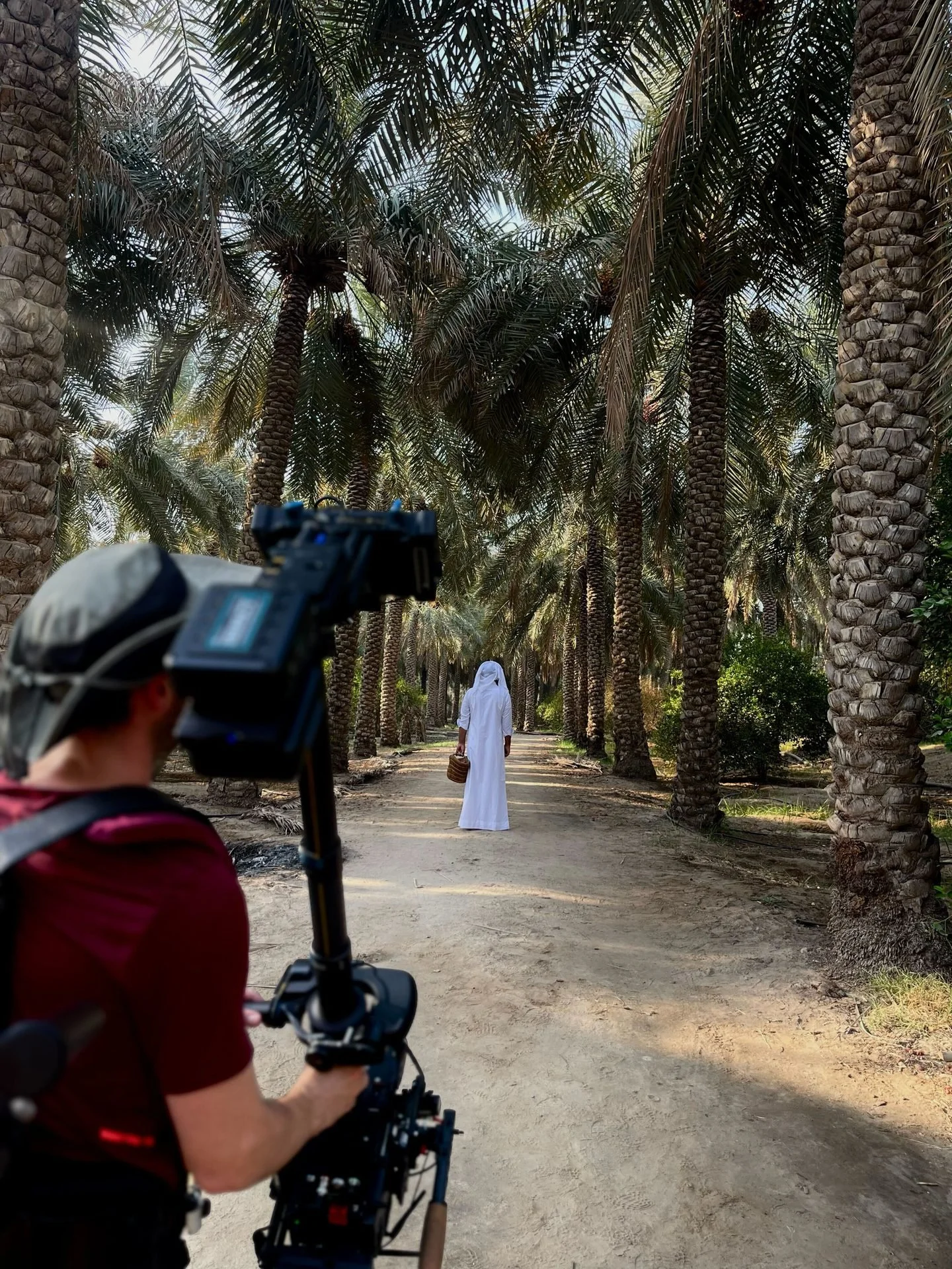 Film crew discussing the next setup among palm trees at Al-Ahsa for Evolving Cities