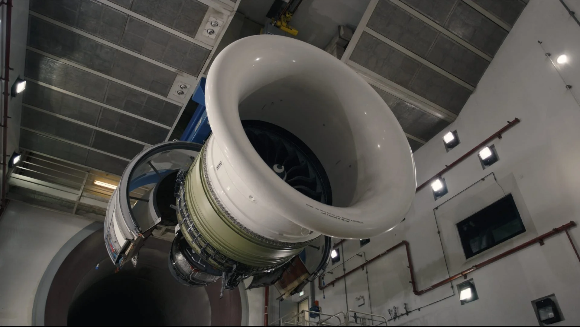 GE Aviation jet engine mounted in test cell facility — wide dramatic angle,
GE digital transformation film series
