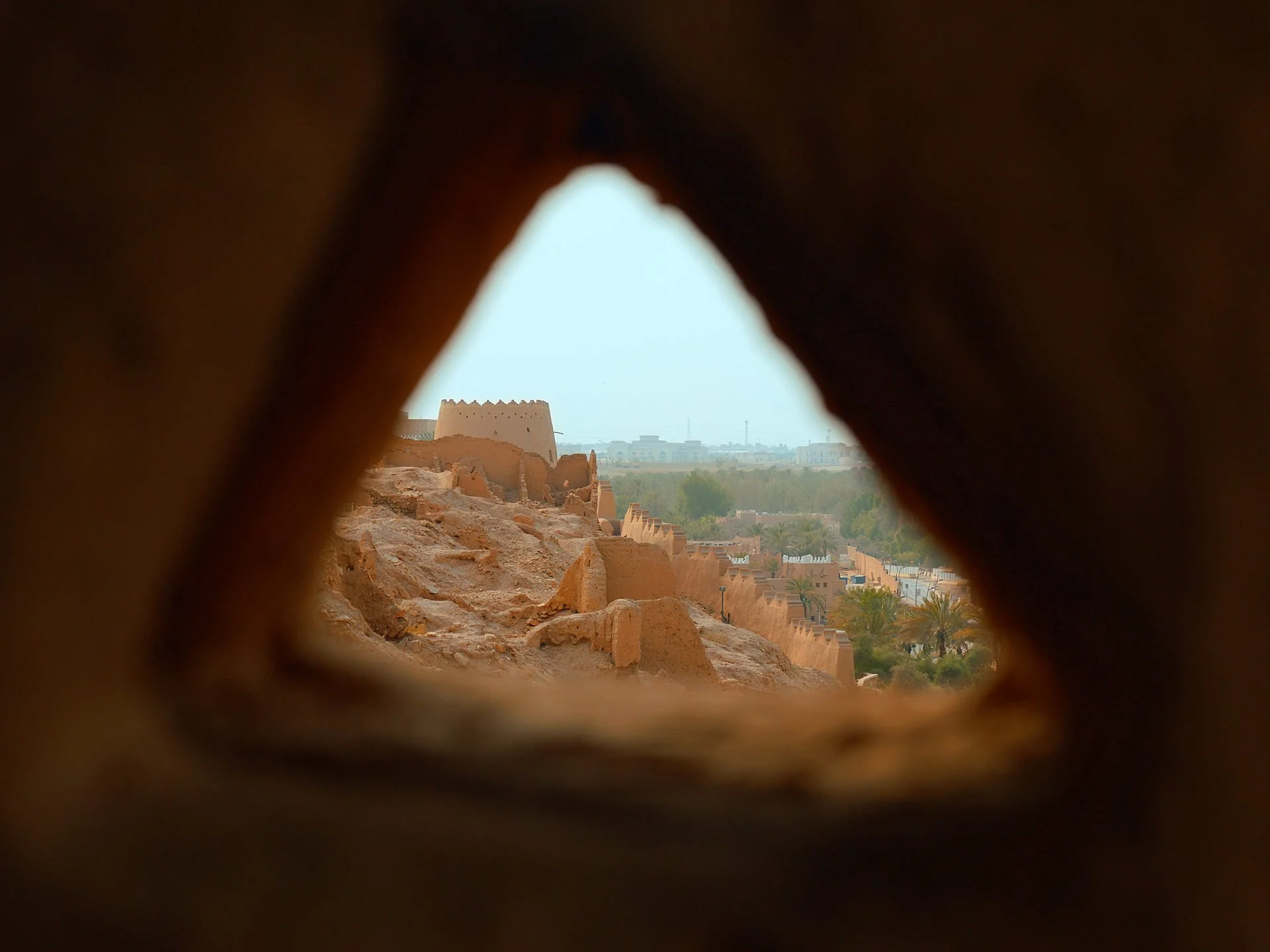 The ancient Diriyah fortifications framed through a triangular opening in a mudbrick
wall - the ruins of the first Saudi capital, a UNESCO World Heritage site in Riyadh