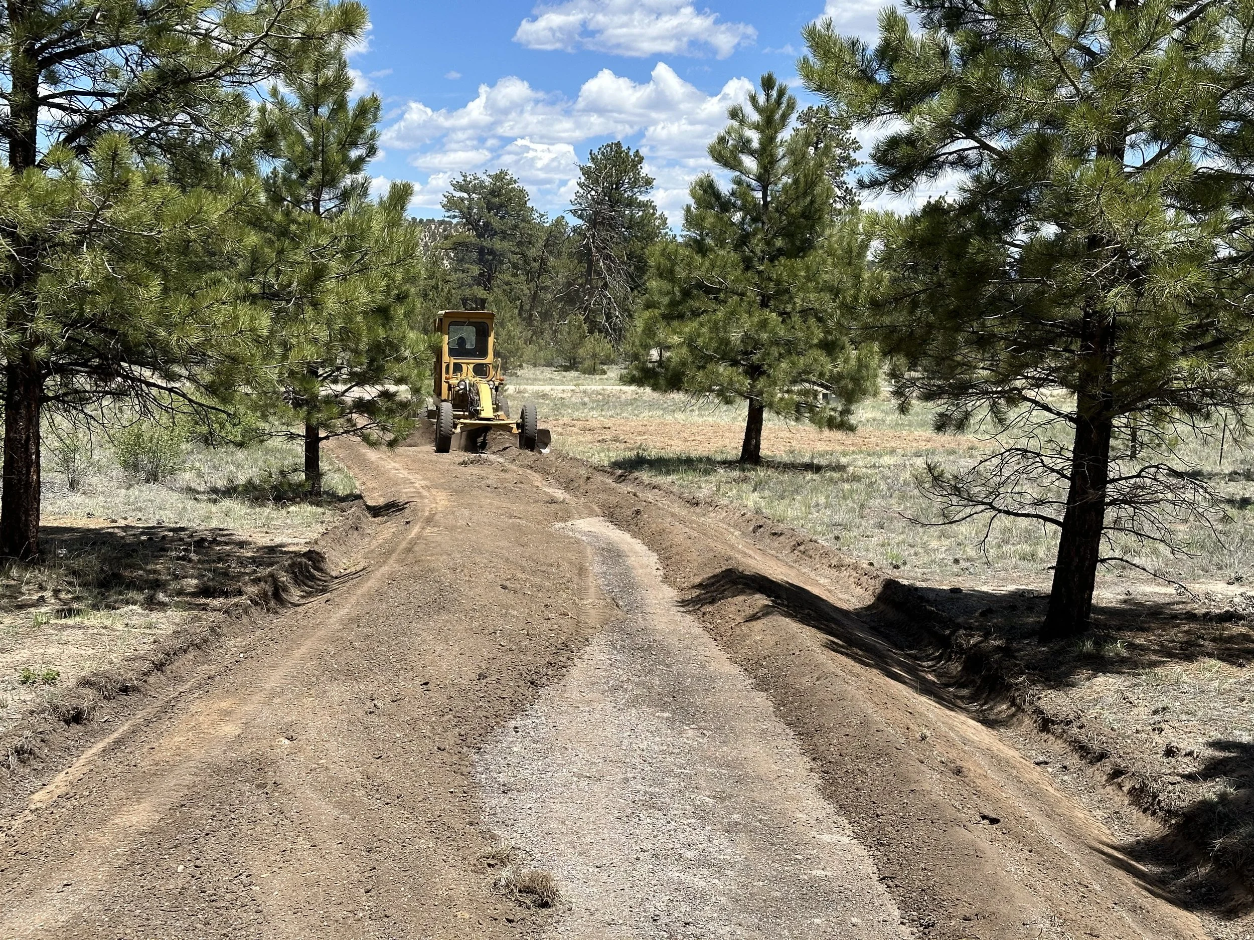 Motor grader restoring the crown of a private HOA road in Buena Vista, Colorado