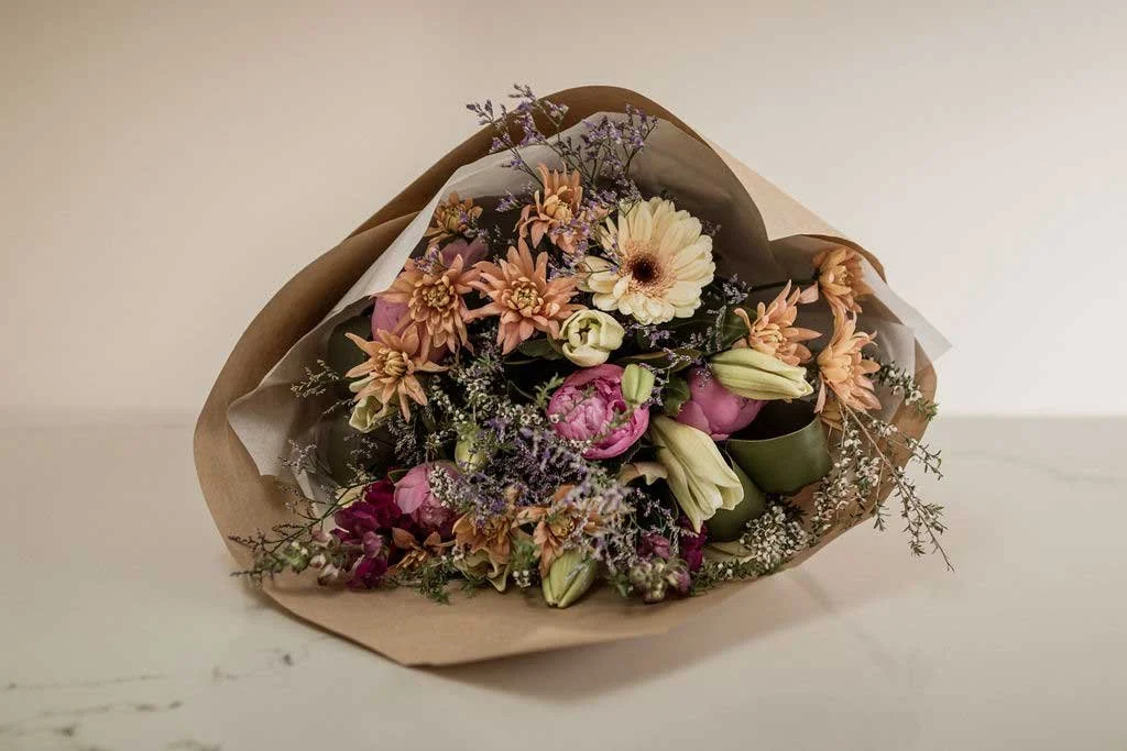 bouquet of flowers wrapped laying on table (Copy)