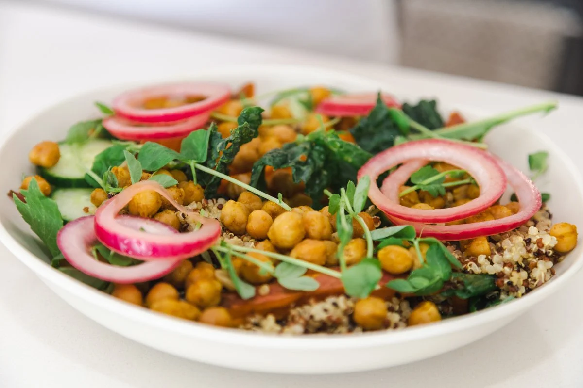 A bowl of chickpeas, quinoa, kale and pickled onion