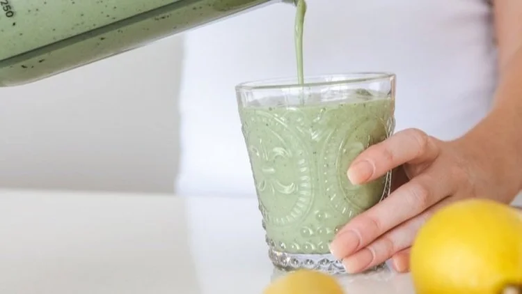 Fresh green smoothie being poured into a glass