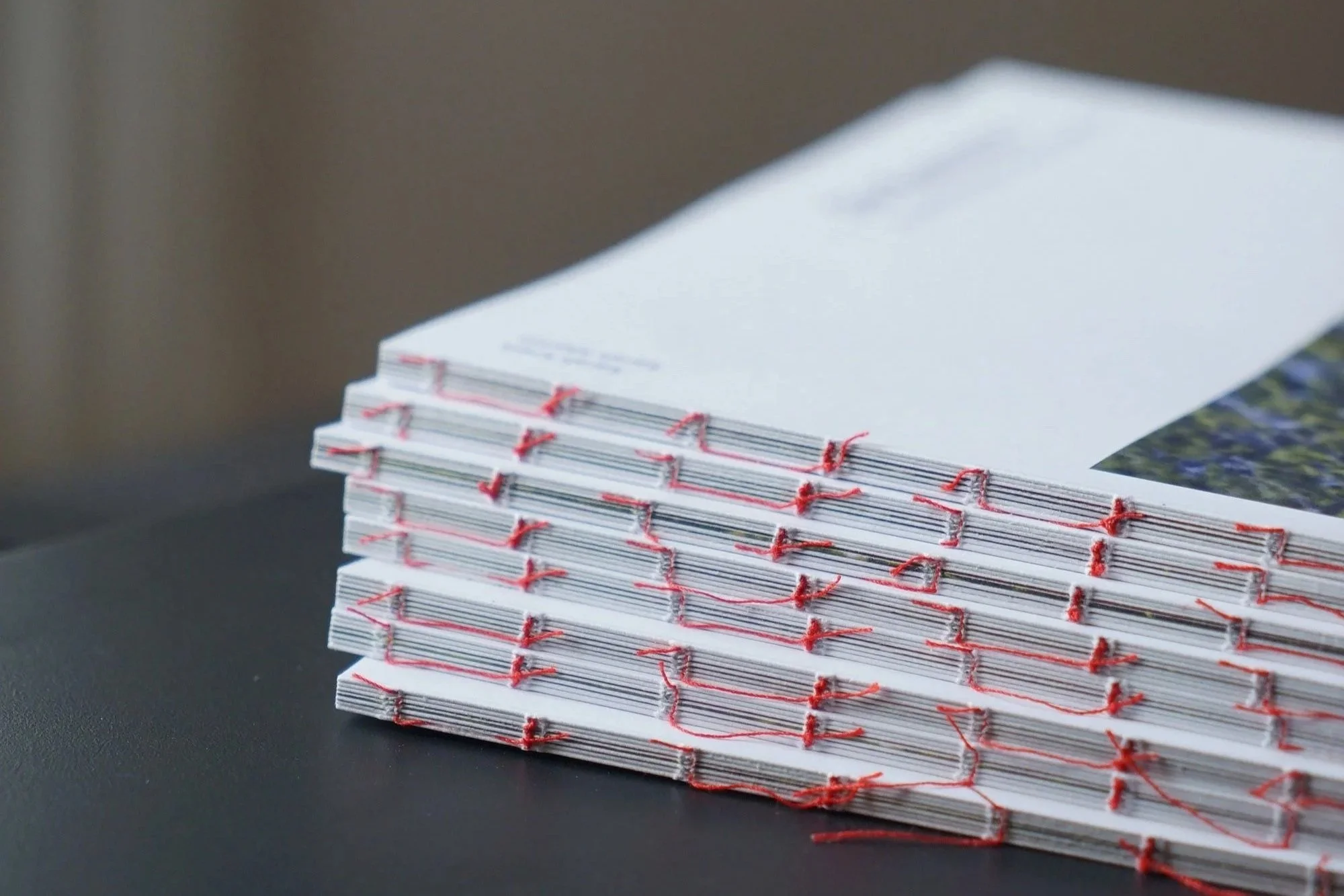 Gestapelte Journale mit roter offen verklebter Fadenbindung