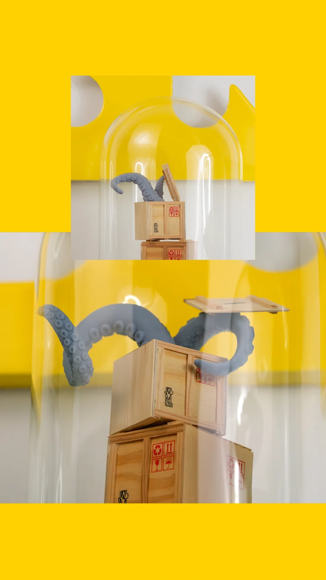 Überraschungsgäste — Close-up auf einen Glasdom, in dem aus einem Stapel Miniatur-Cargo-Kisten zwei Krakenarme platzen. Wehe dem, der …