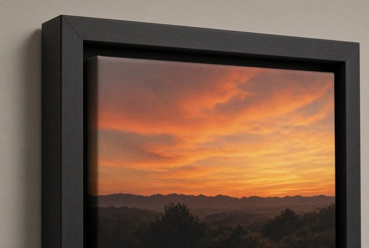 Corner of a sunset canvas print in a black float frame on a wall