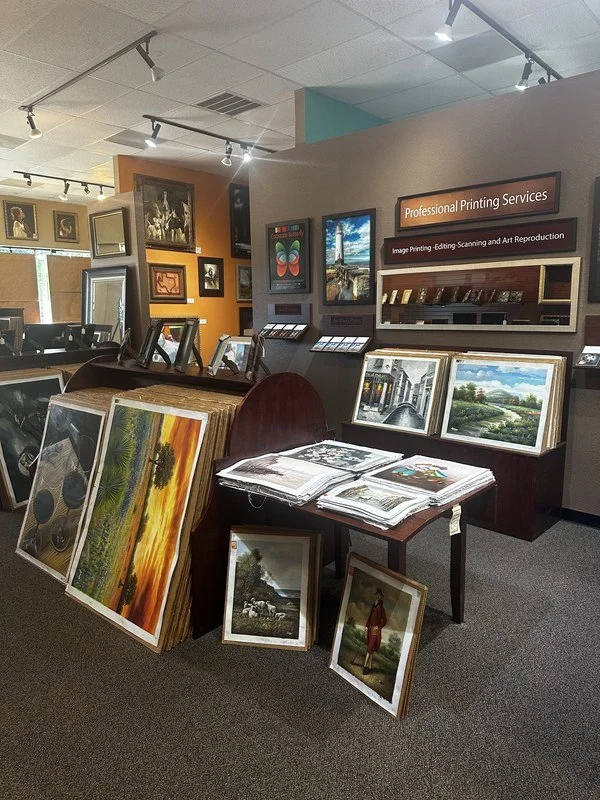 Inside The Frame Gallery in San Antonio, with paintings for sale and the printing wall