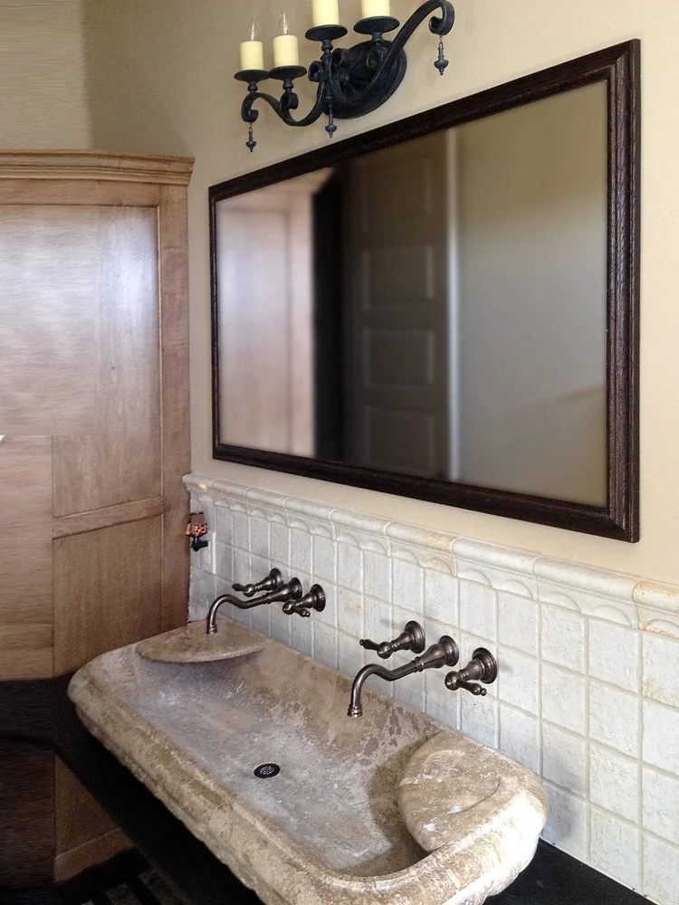 Dark oak custom framed bathroom mirror above a trough sink