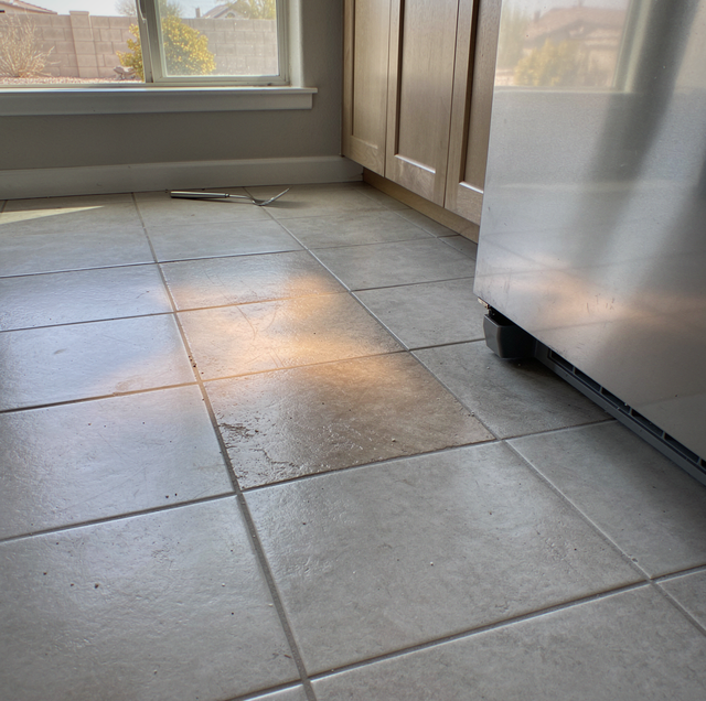 barefoot on warm tile near kitchen cabinet