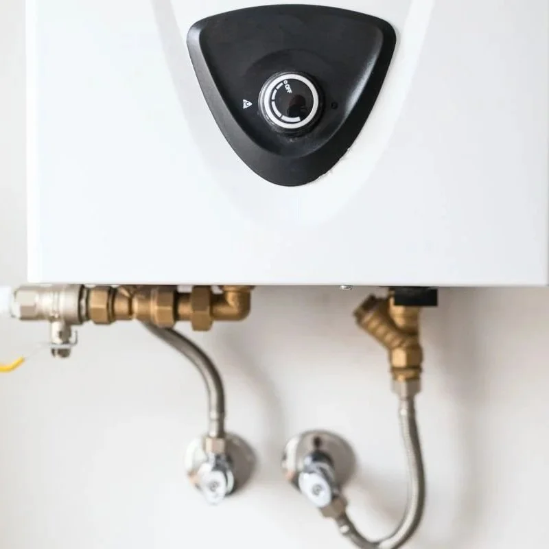 A wall-mounted electric water heater featuring brass pipe fittings and adjustable temperature control for efficient home water heating systems.