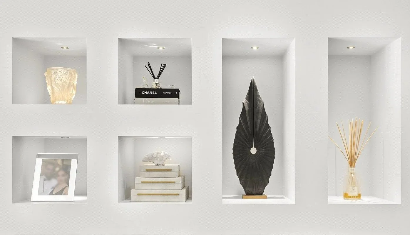 Eternal in Ebony, a tall black leaf-form ash sculpture by Pav Patel, displayed in a lit white wall niche