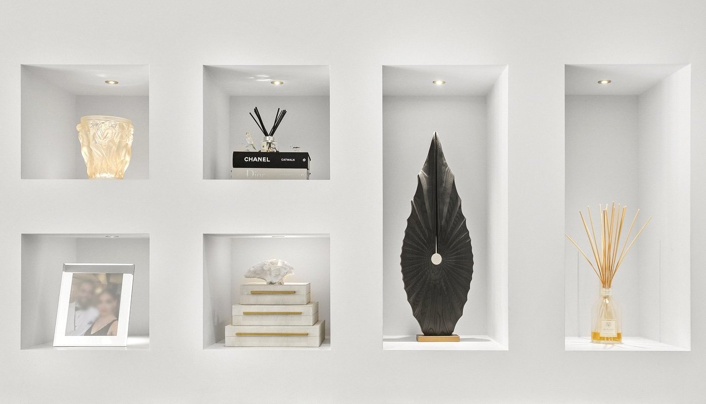 Eternal in Ebony, a tall black leaf-form ash sculpture, displayed in a lit white wall niche