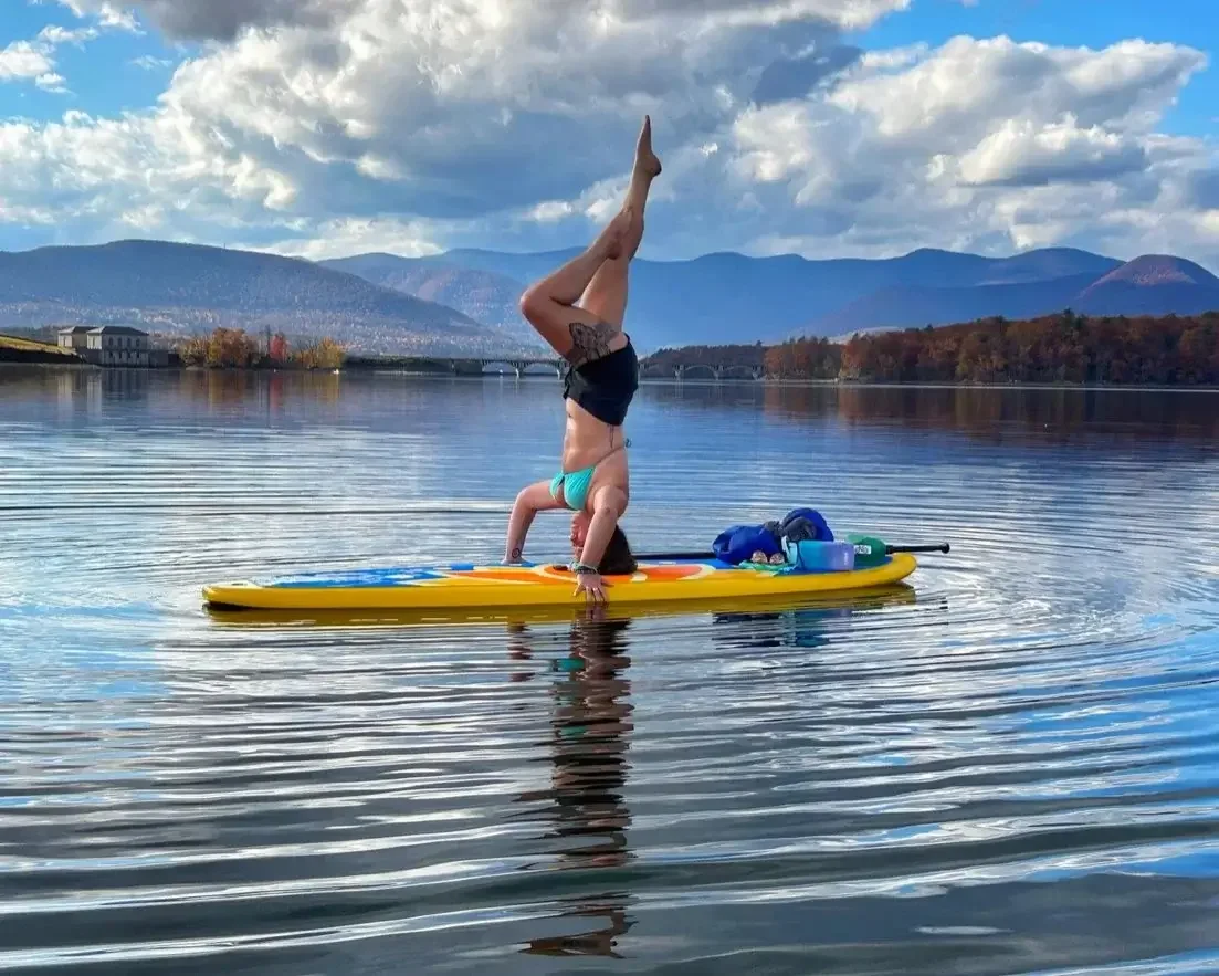 Yoga instructor Jessie Murray is seen doing a handstand on a paddleboard in the water.