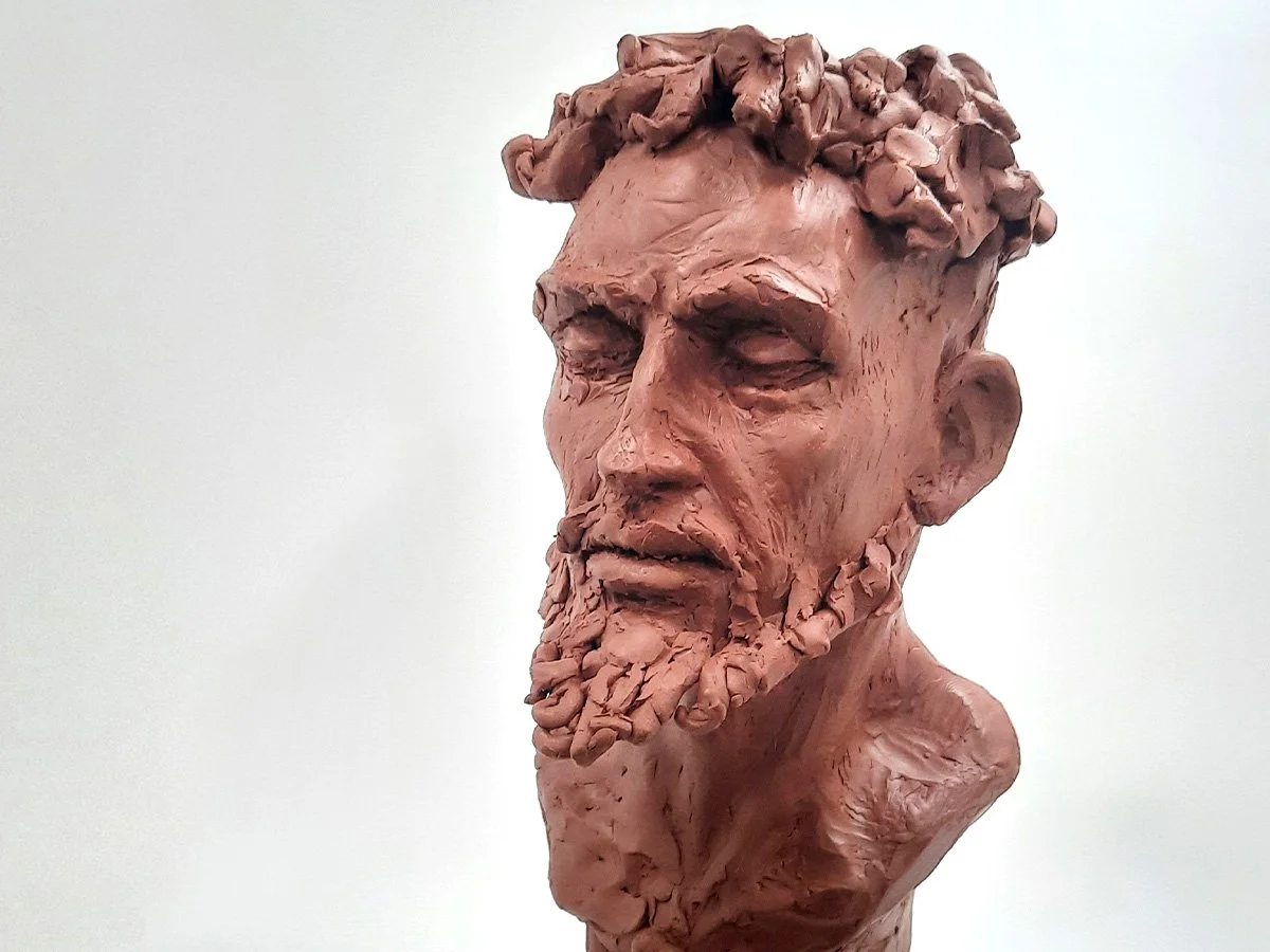 clay bust of figure with beard and curly hair