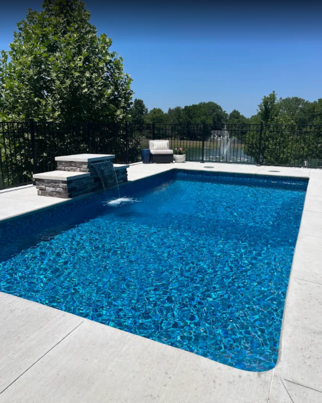 Waterfall next to a pool on sunny day in Kansas City built by Super Pools