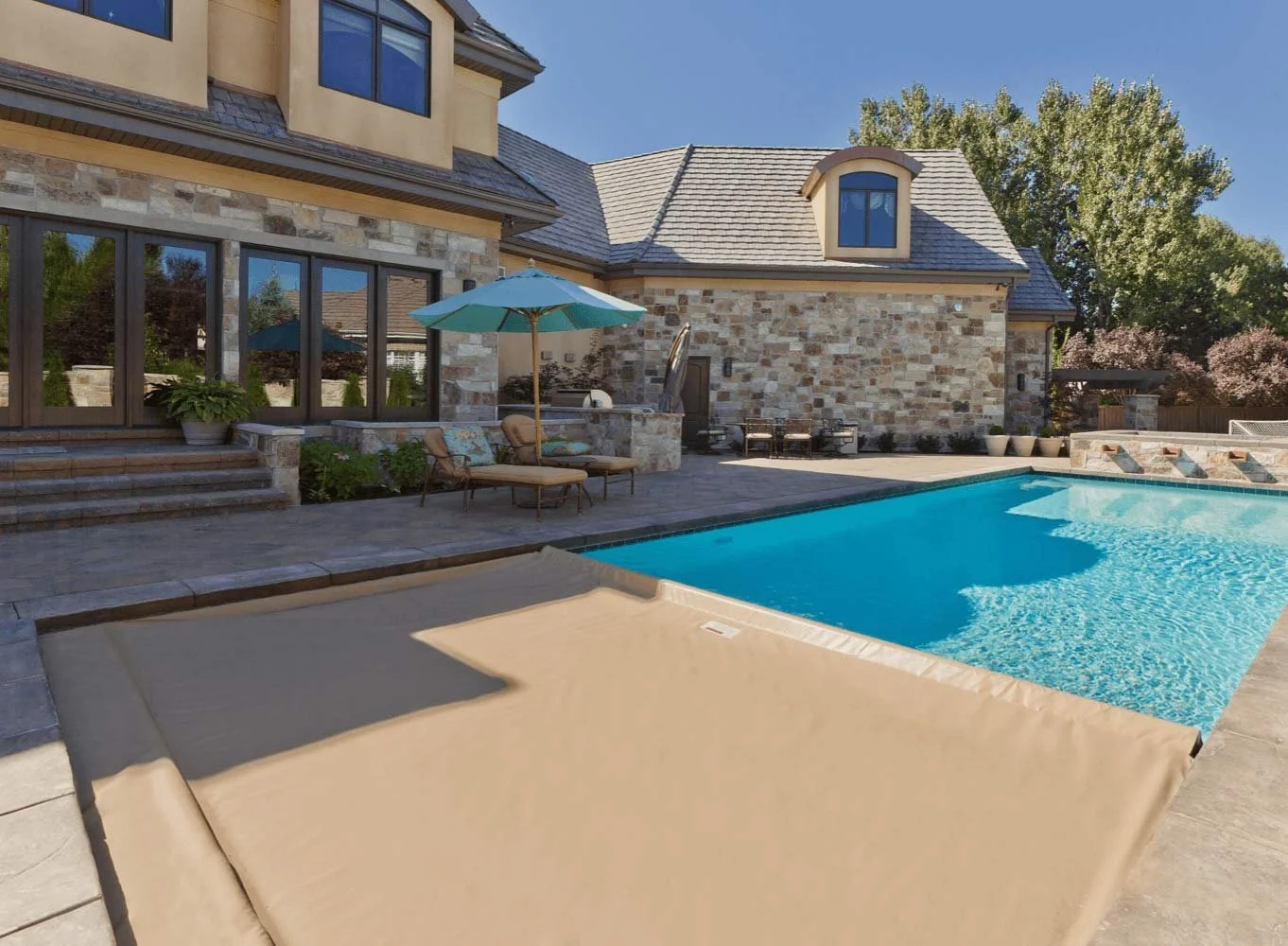 Tan colored auto cover closing on a blue pool in Kansas