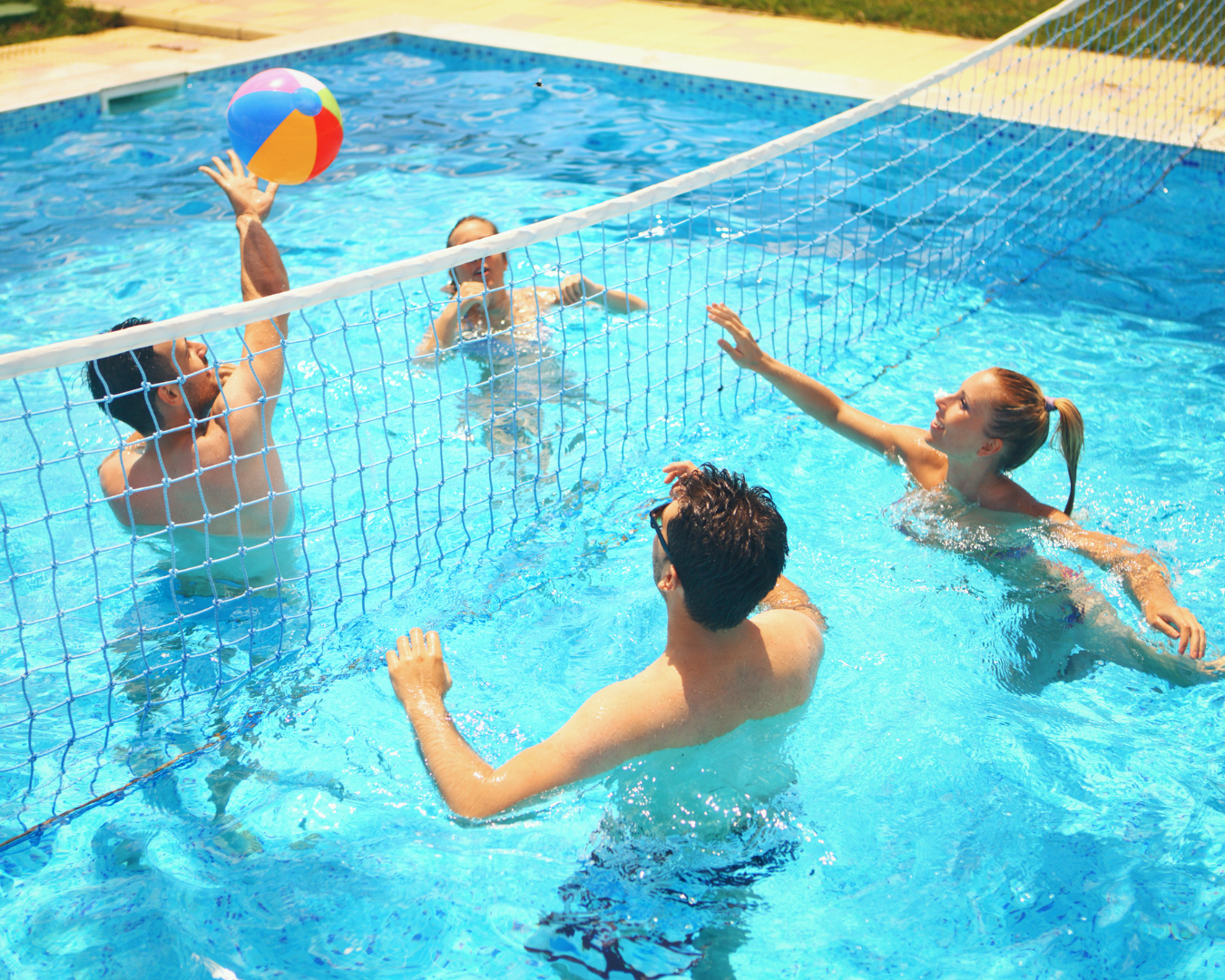 Four people playing volleyball in a sport pool in Kansas