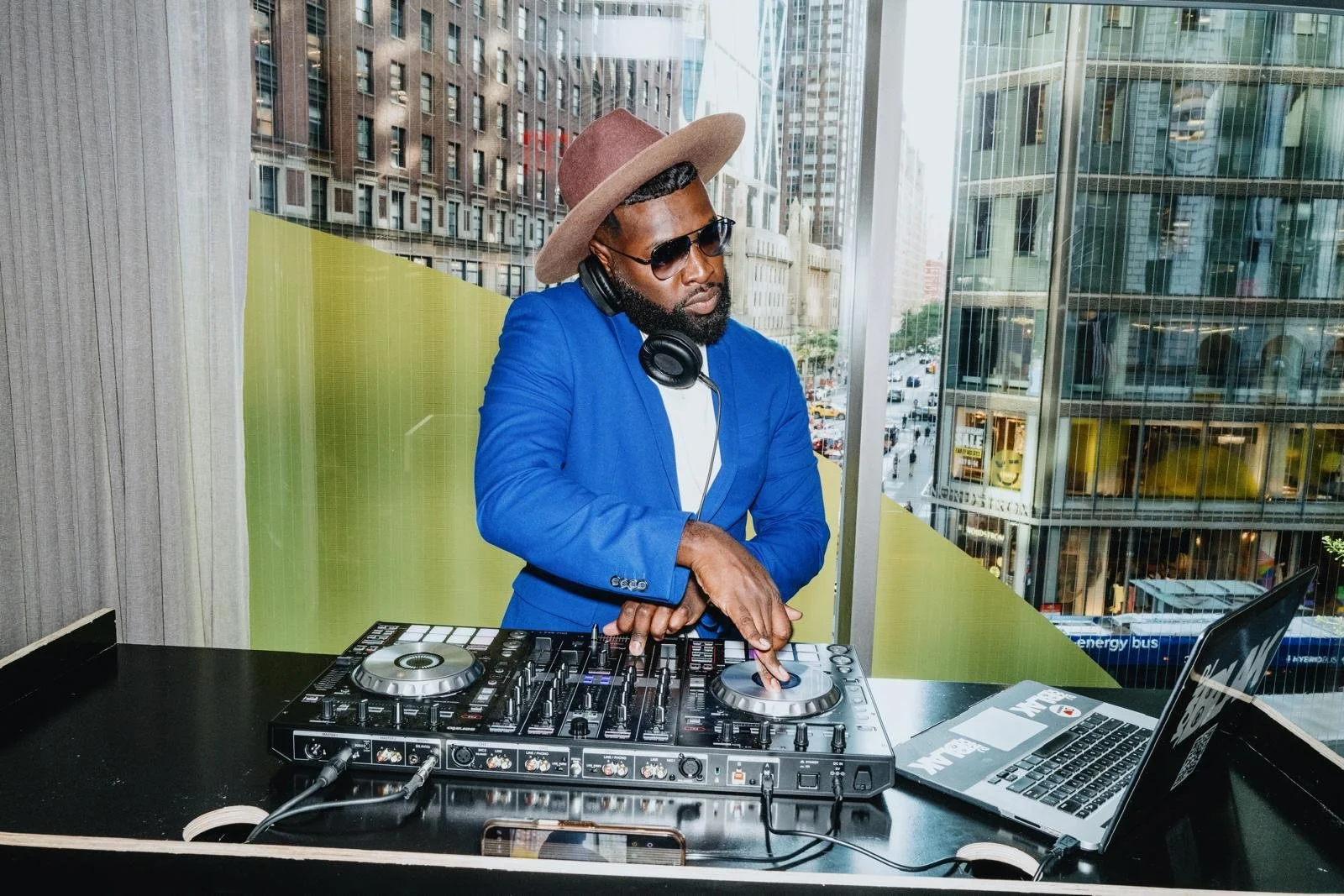“NYC Wedding DJ & MC DJ Jon Blak mixing live music at a modern city-view venue, delivering professional DJ services for weddings, corporate events, and sports events in New York City.”