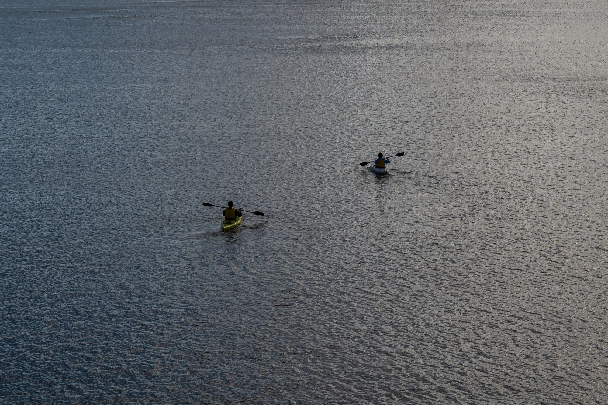 Two people kayaking on Lake Pocotopaug during sunset in East Hampton, CT.