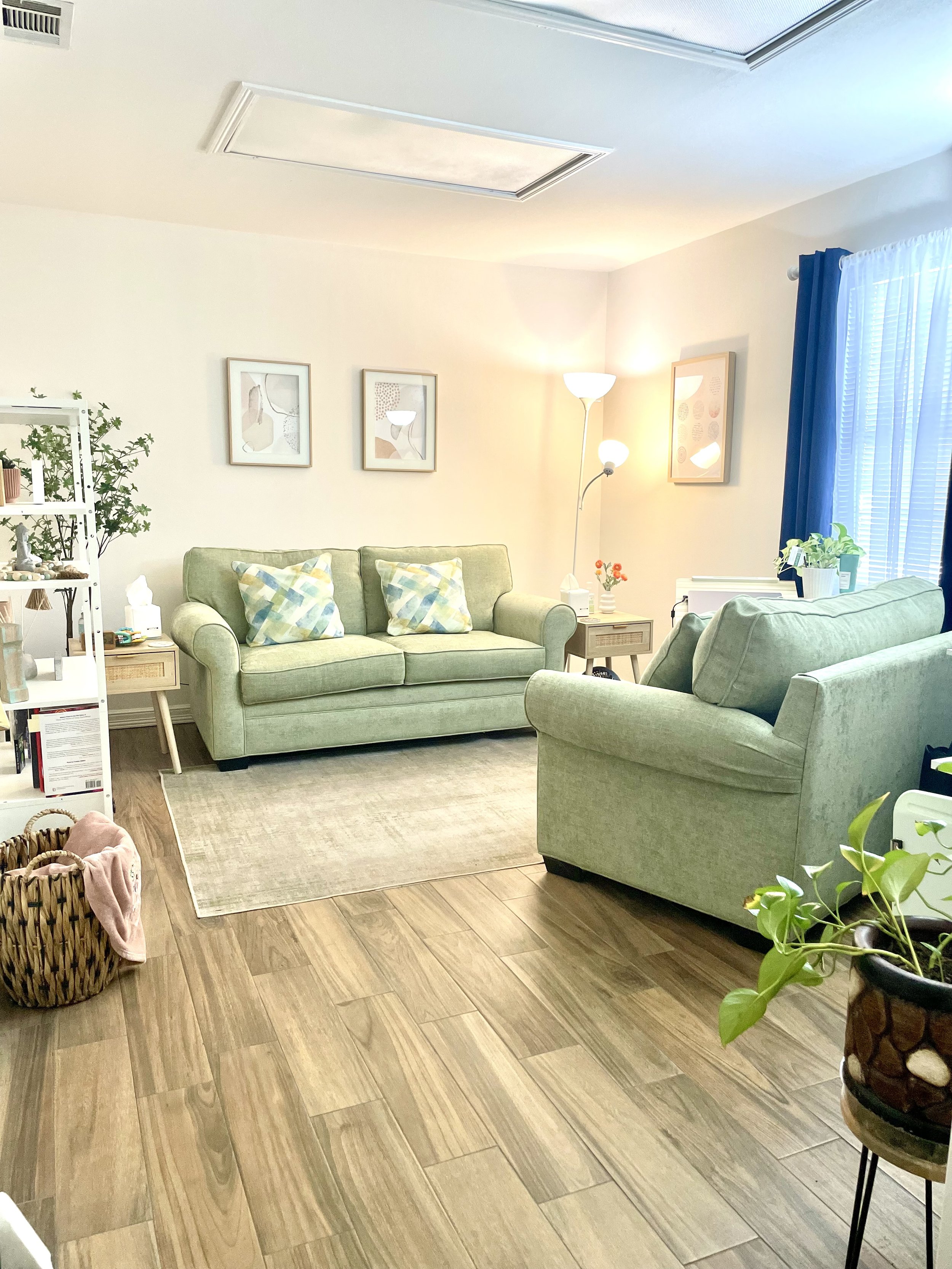 Inner Solace Therapy's office with green sofas, plants, and natural light