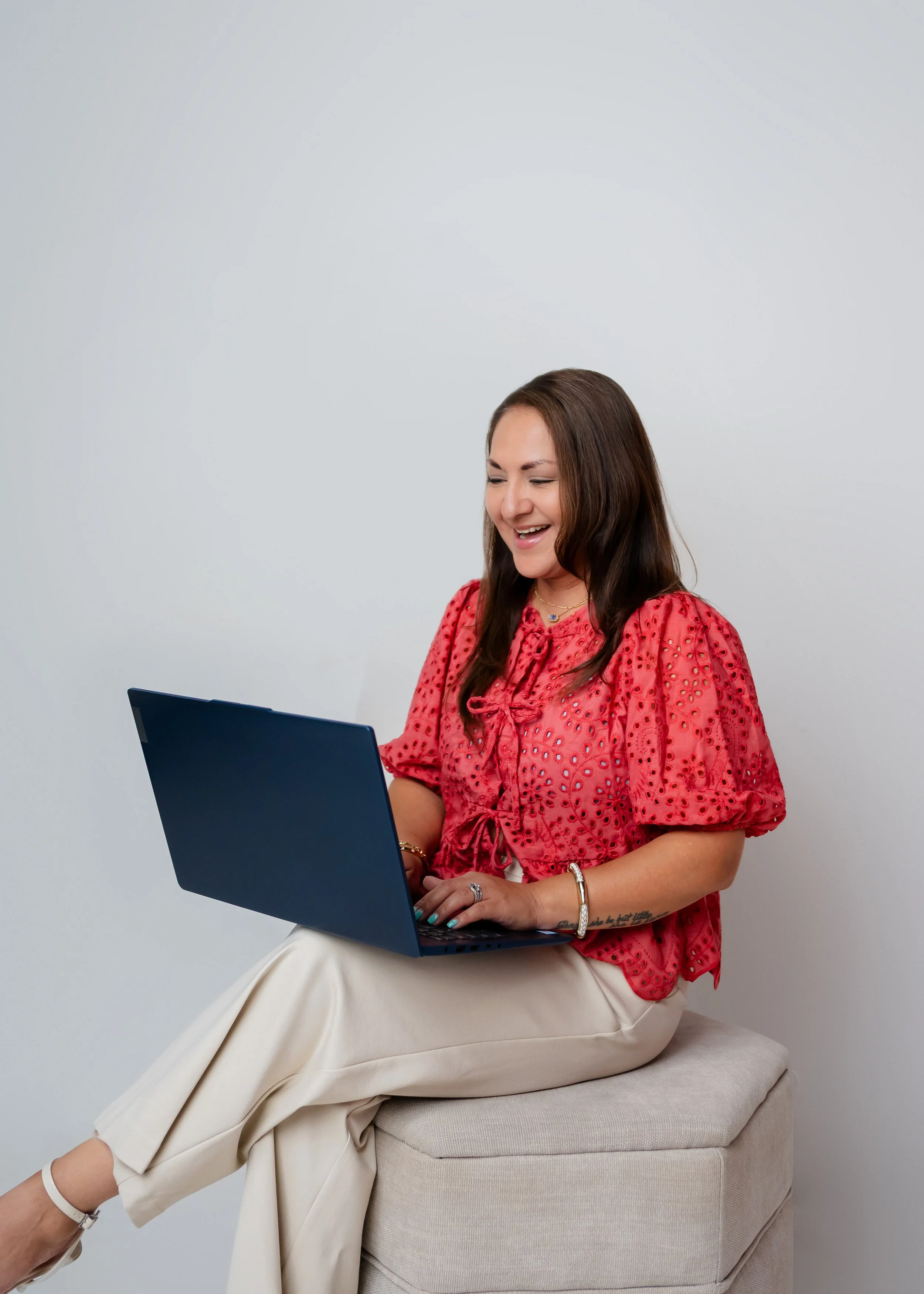 Valerie Rivera working on her laptop in a bright, neutral office setting