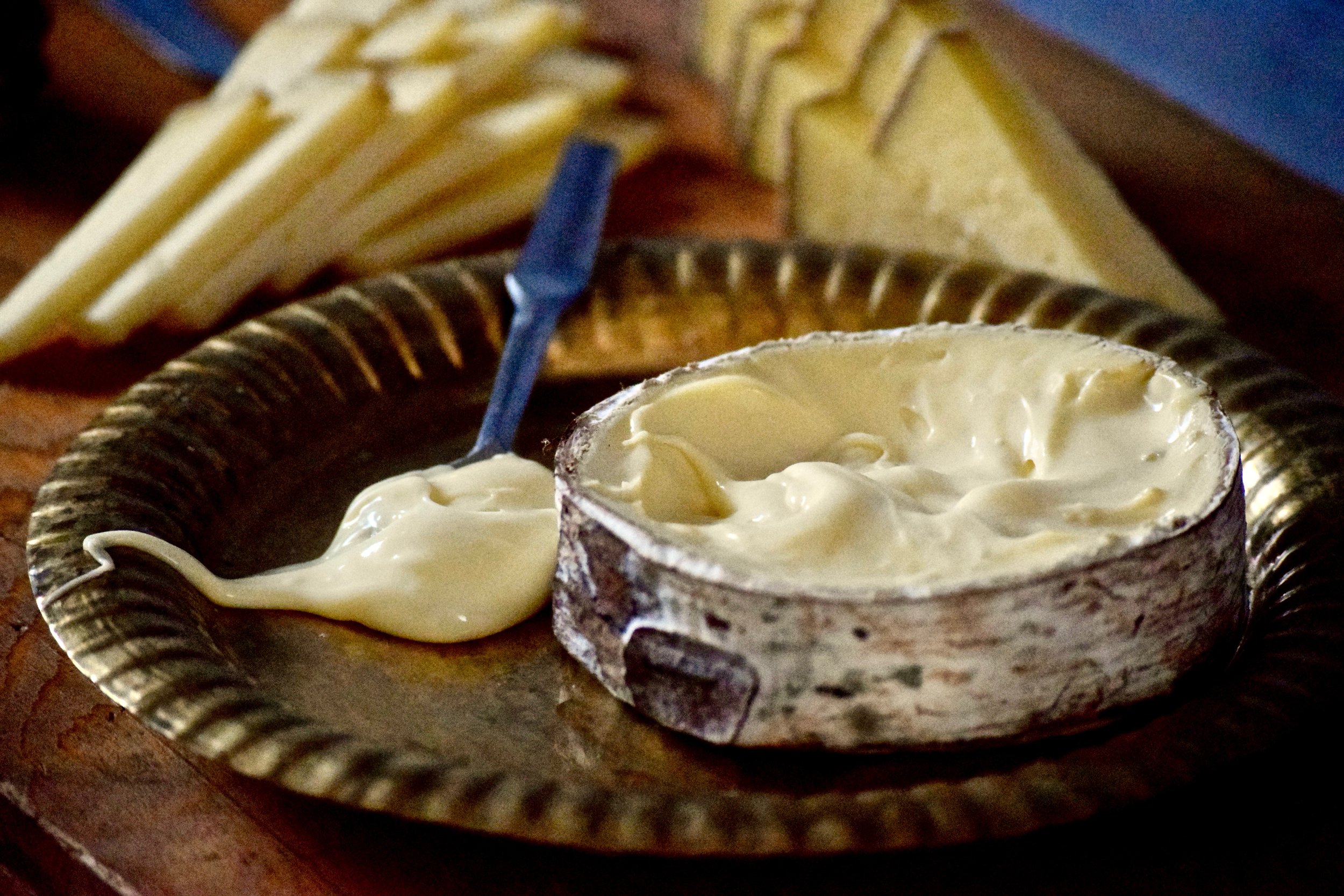  Beauty shot of ripe Haribson, top rind removed and a spoonful of the cheese beside the wheel 