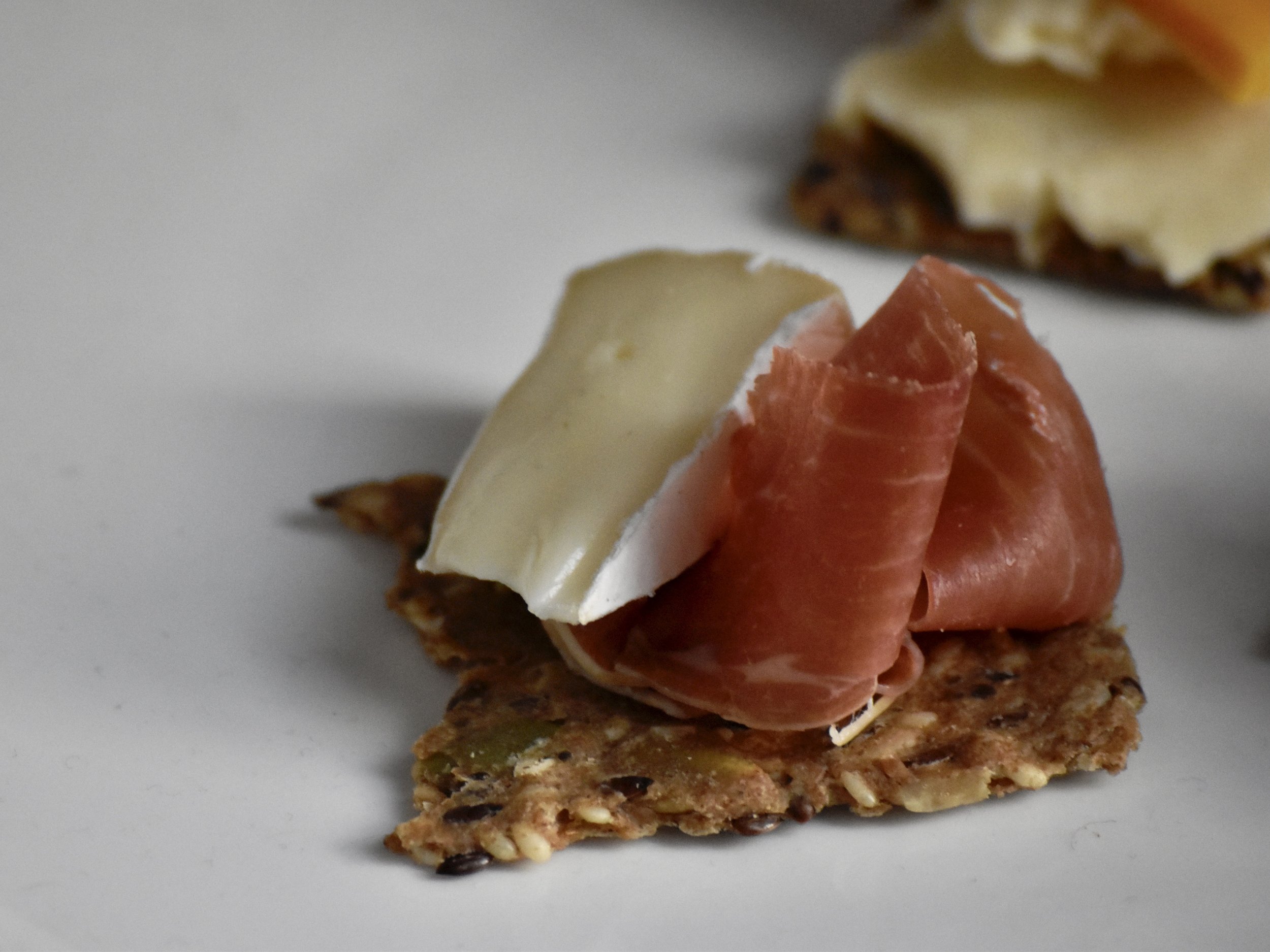  A perfect bite of Little Hosmer on a cracker with proscuitto  