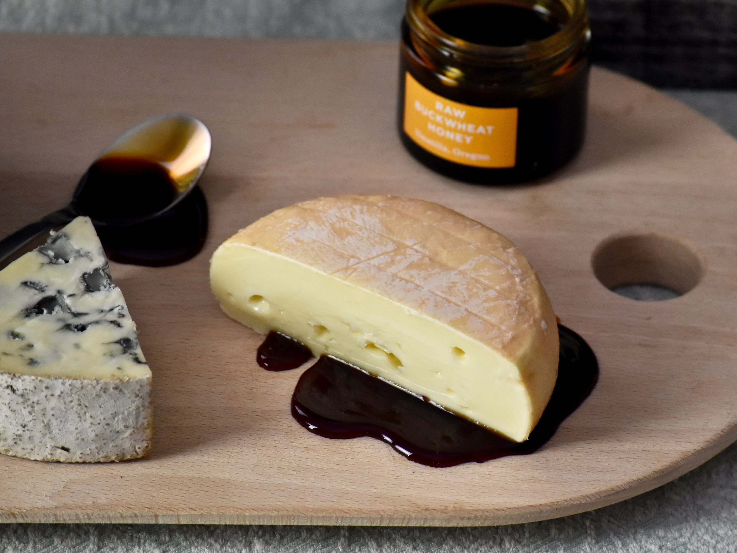  Two pieces of cheese with pairings on a serving board 