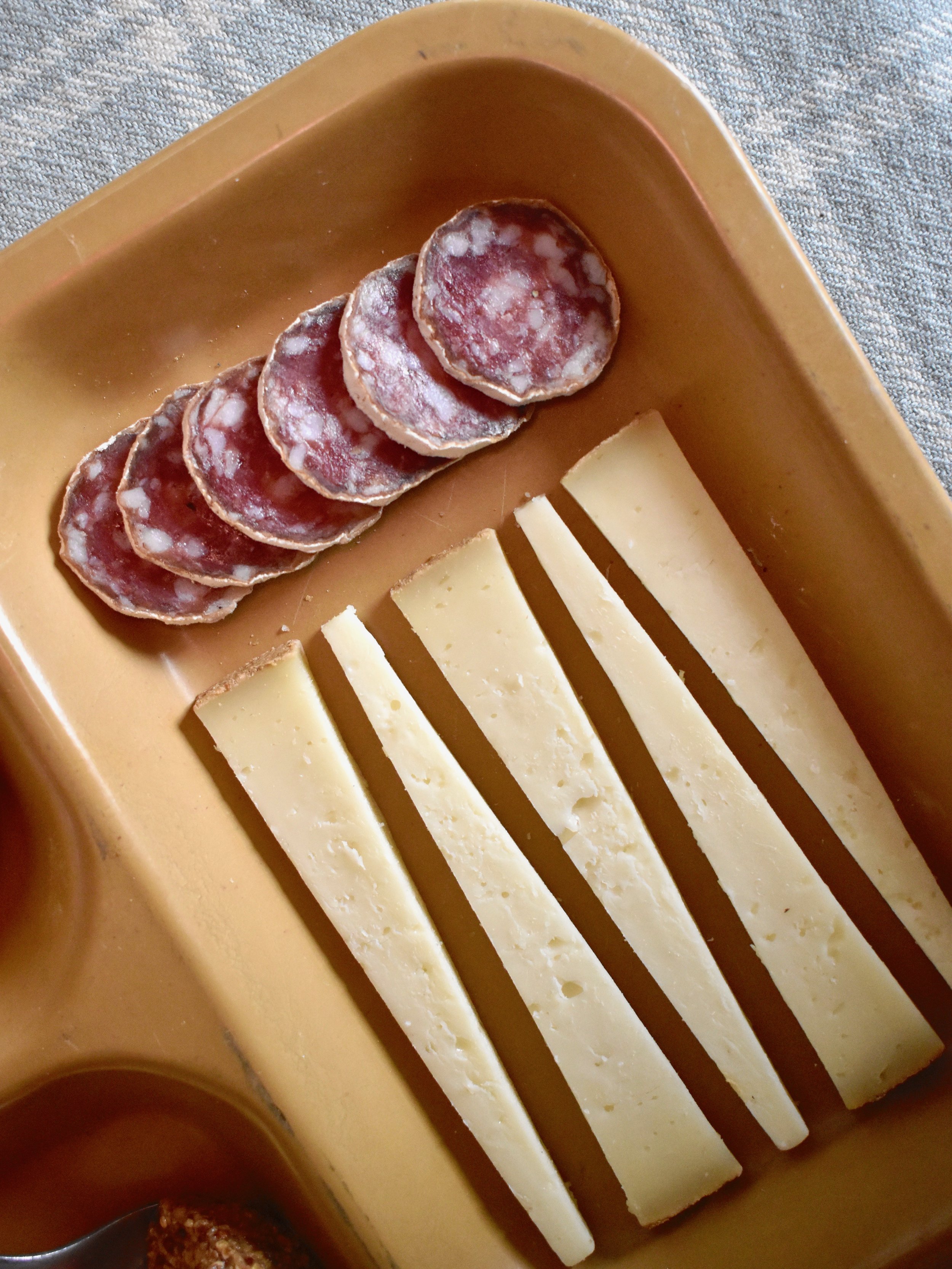 Meticulously cut triangles of Cabot Clothbound Cheddar with salami 