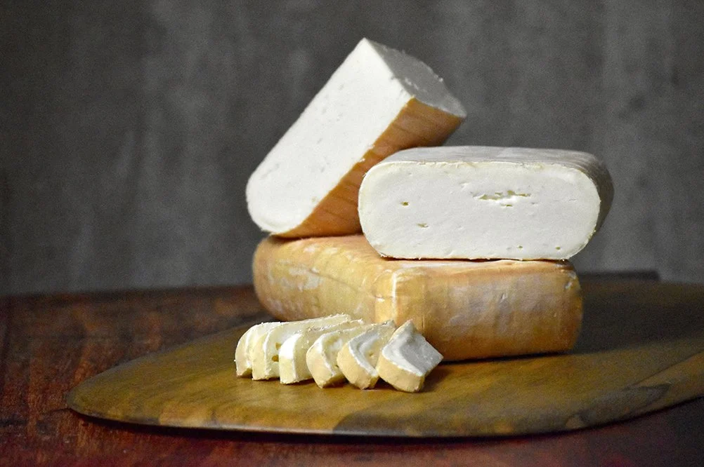 Eligo, a washed rind goat cheese, cut and presented to show smooth white paste and orange rind