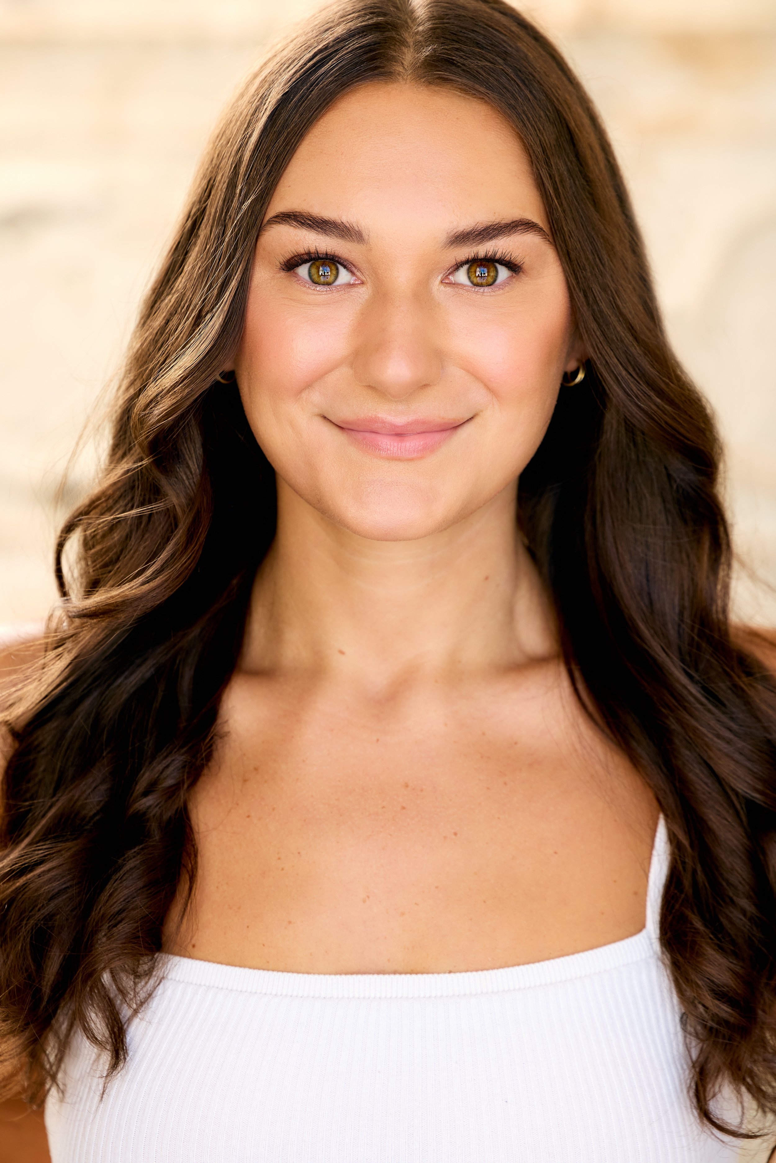 Abby Rae Marcus's headshot where she looks straight towards the camera with a smile in a white tank top.  Taken by Paul Smith Photography.