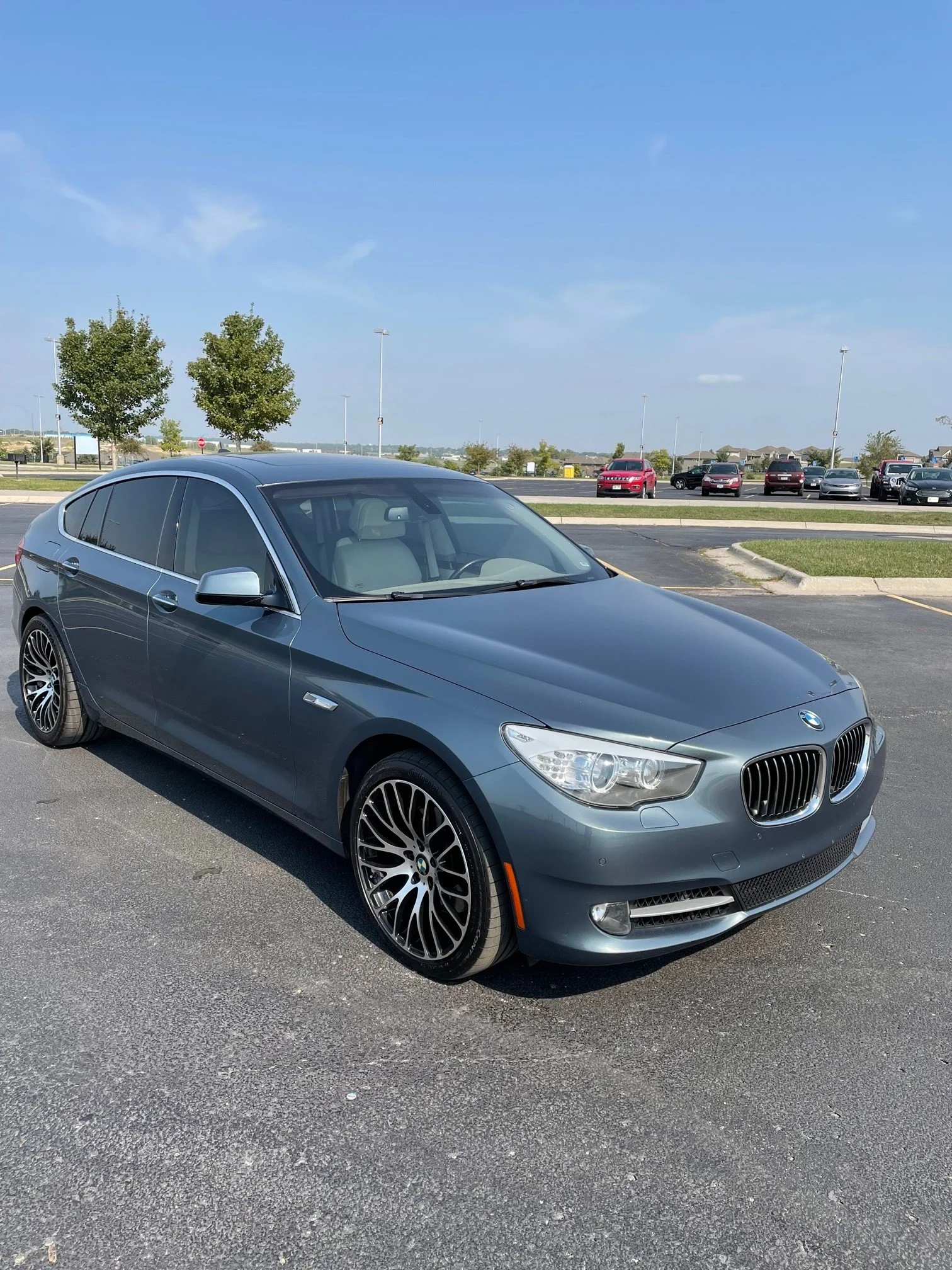 A gray BMW sedan parked in a parking lot on a sunny day.