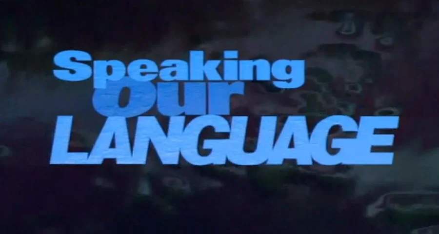 Text that reads 'Speaking our LANGUAGE' in bold blue letters on a dark background.