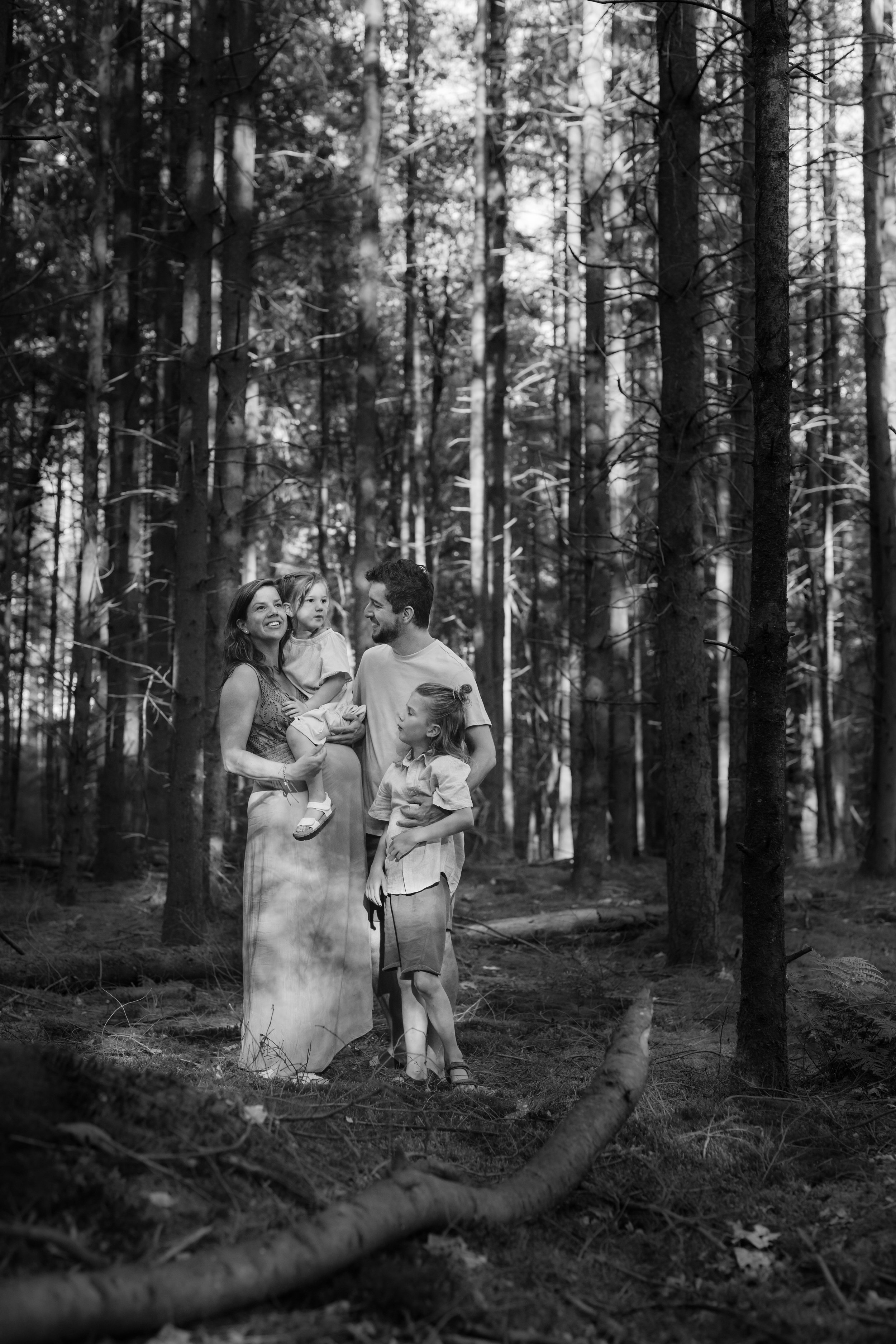 Gezin in bosrijke setting, zwartwit foto, Drentse bossen, familiefoto.