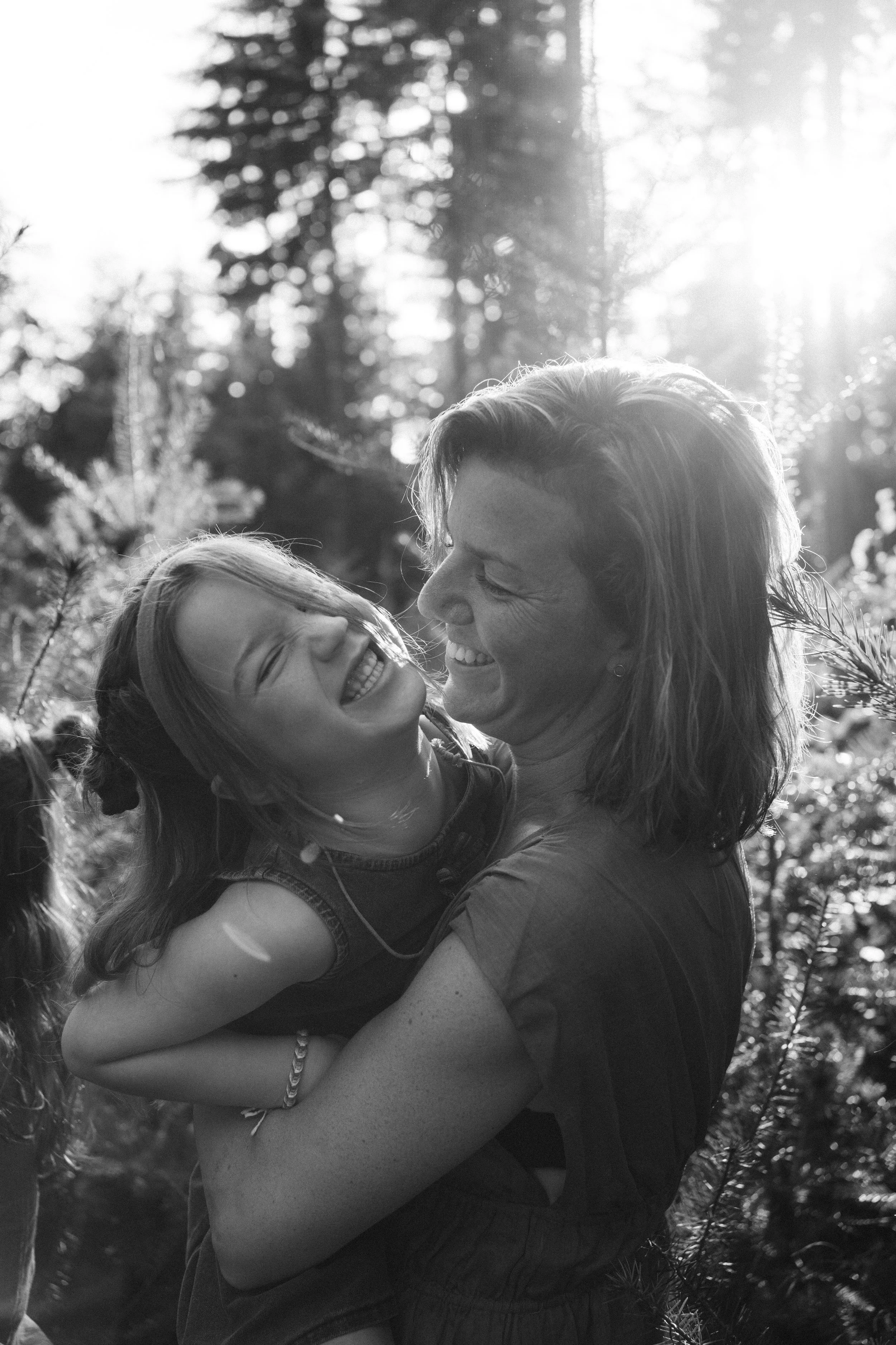 Moeder en dochter in bosrijke setting in zwart wit.