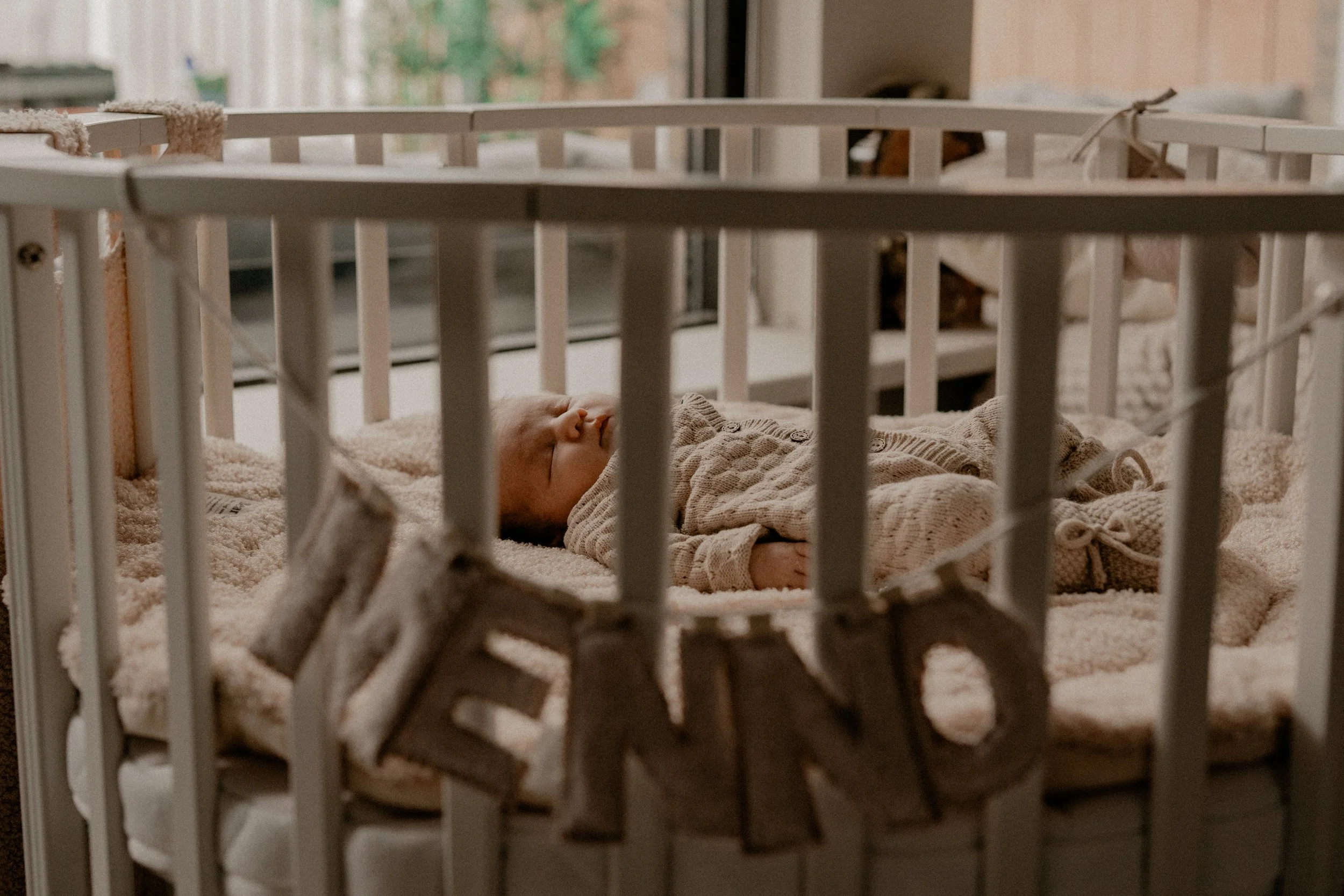 Pasgeboren Newborn baby ligt in de box te slapen, lifestyle newborn fotoshoot, documentair fotograaf Assen en Drenthe.