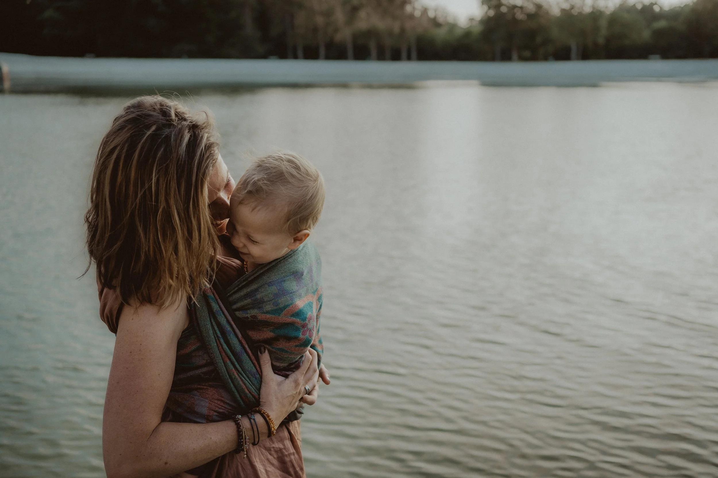 Branding voor draagconsulente, draagdoeken, vrouw met kind in draagdoek bij het water.