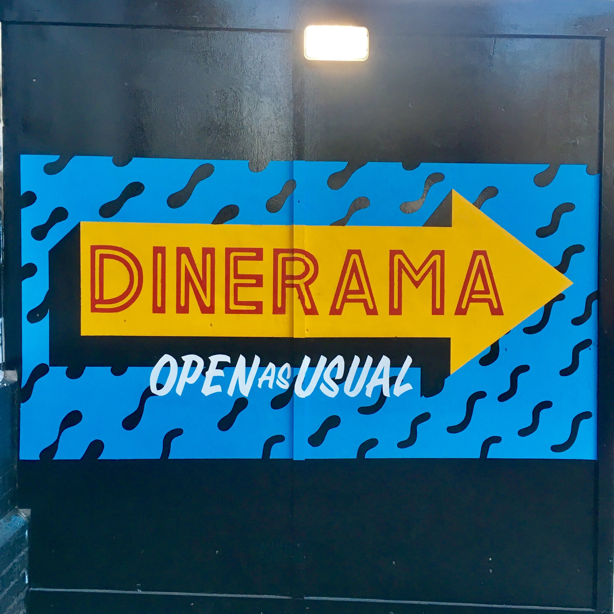 Directional arrow painted onto cladding outside Dinerma whilst building works were taking place. Painting assistance from Adriana.