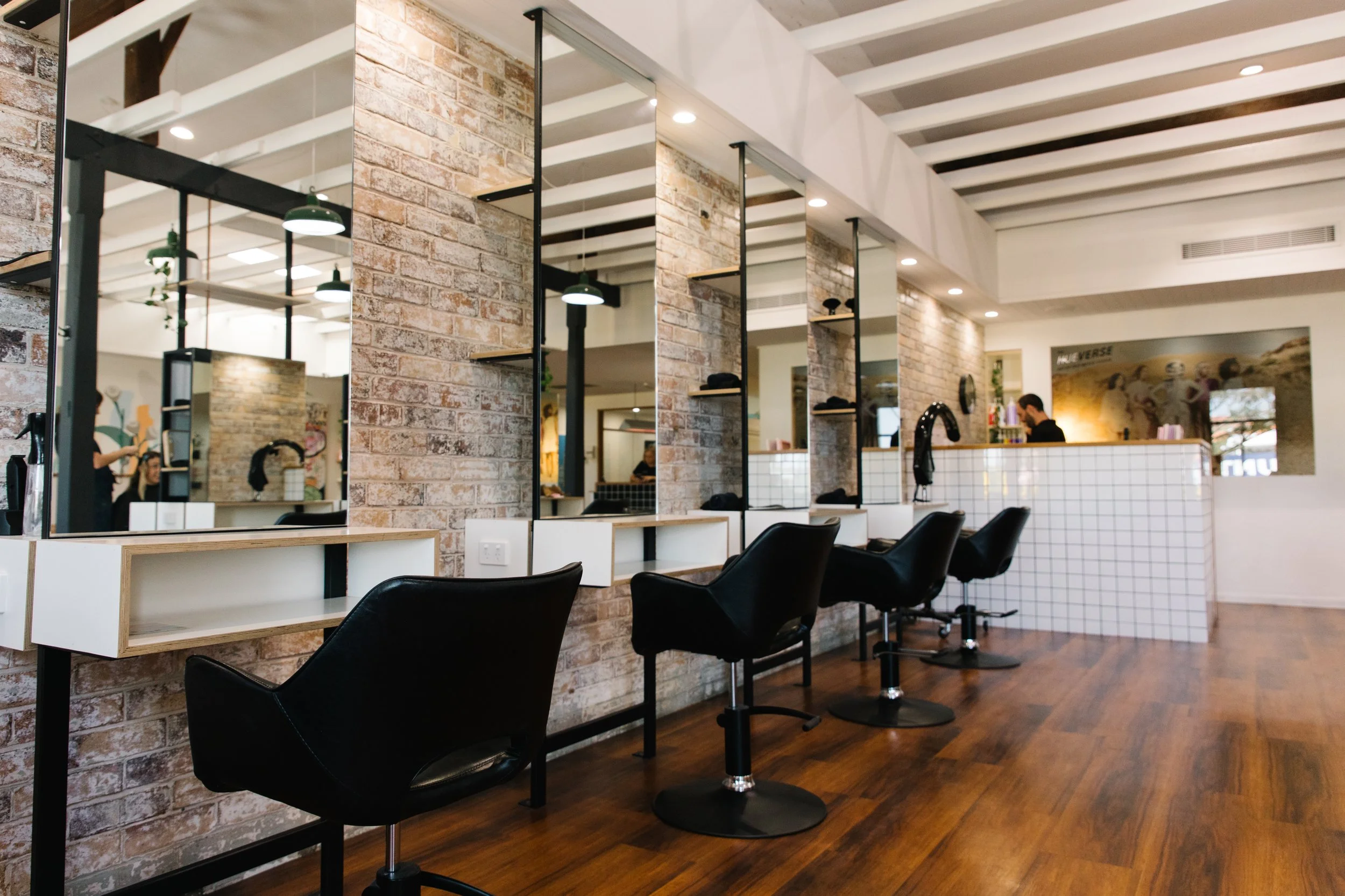 Exposed brick styling stations and mirrors inside Maverick Hair Salon in Coolangatta