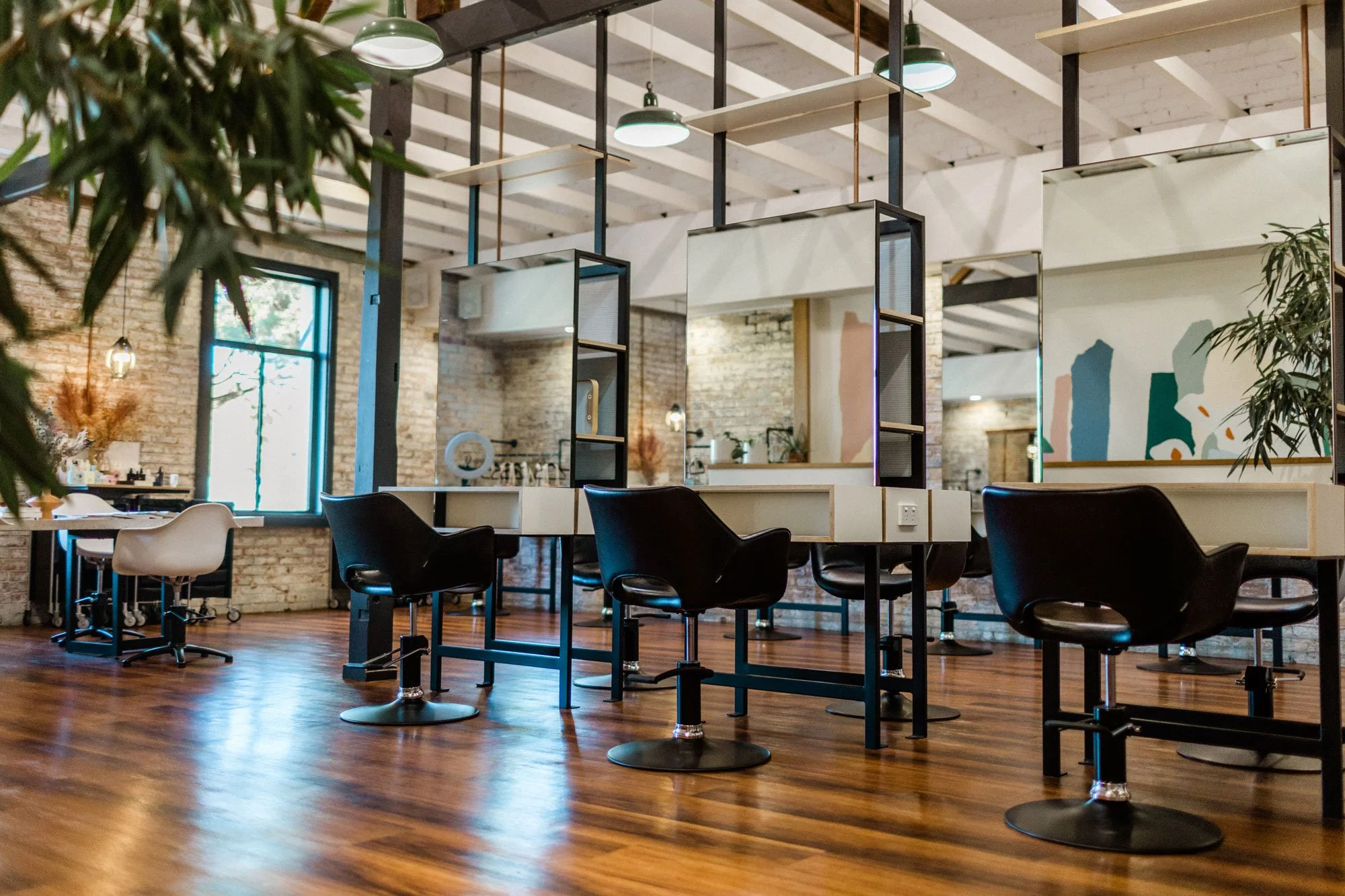 Styling stations, mirrors and hanging plants inside Maverick Hair Salon in Coolangatta