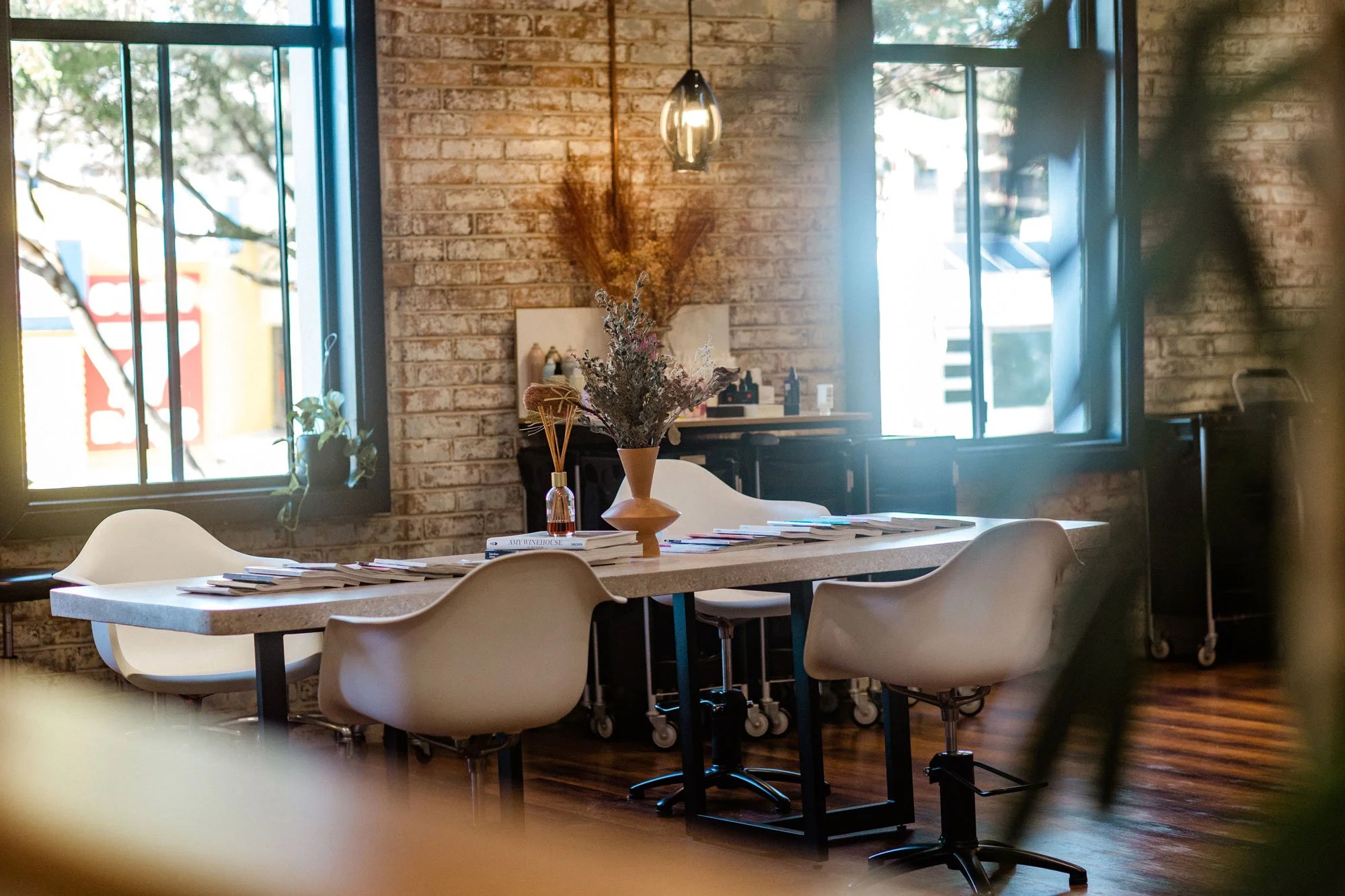 Communal table and exposed brick windows inside Maverick Hair Salon in Coolangatta
