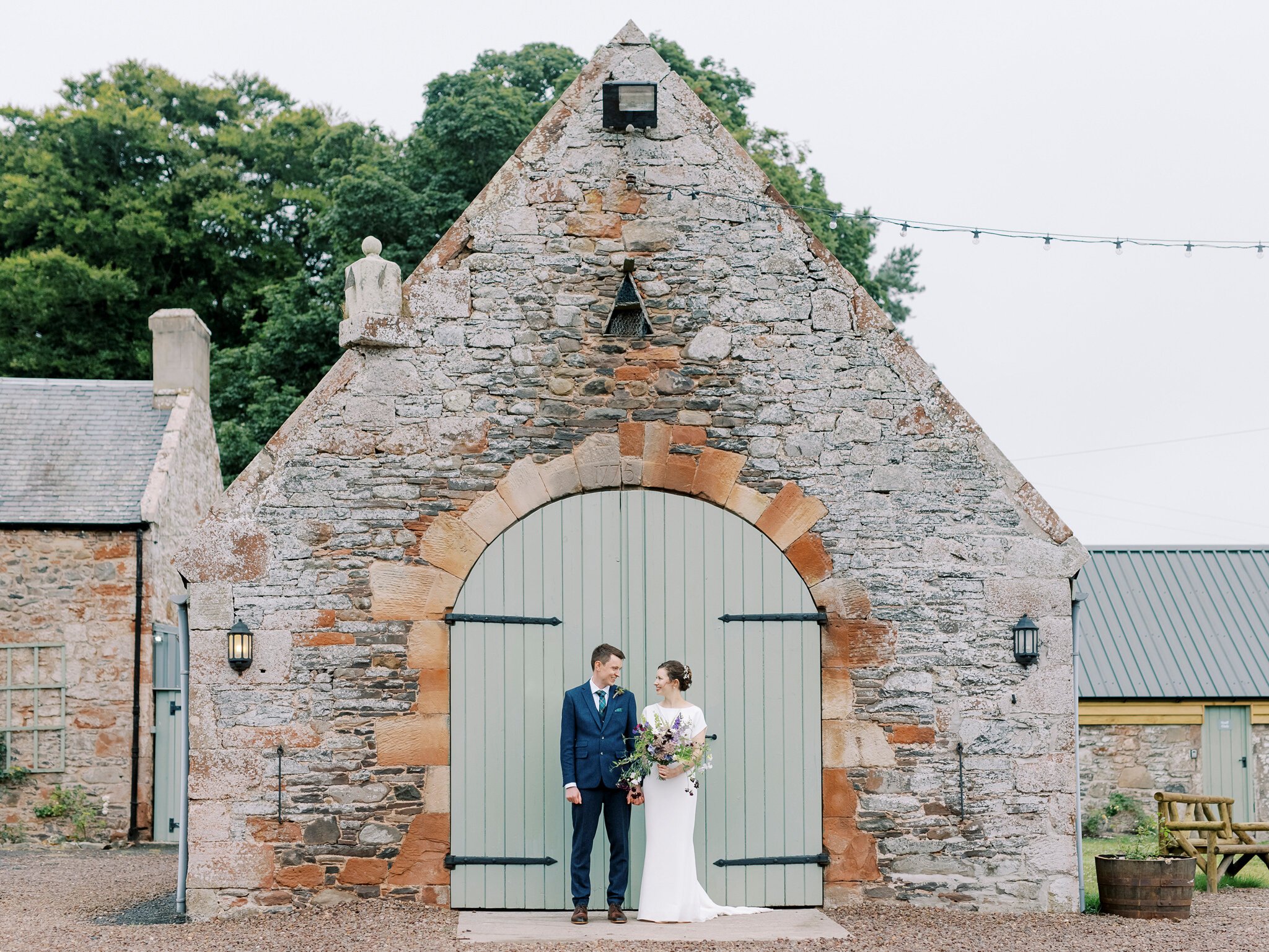 041-wedderlie-house-wedding-scotland-bride-and-groom-infront-of-barn.jpg
