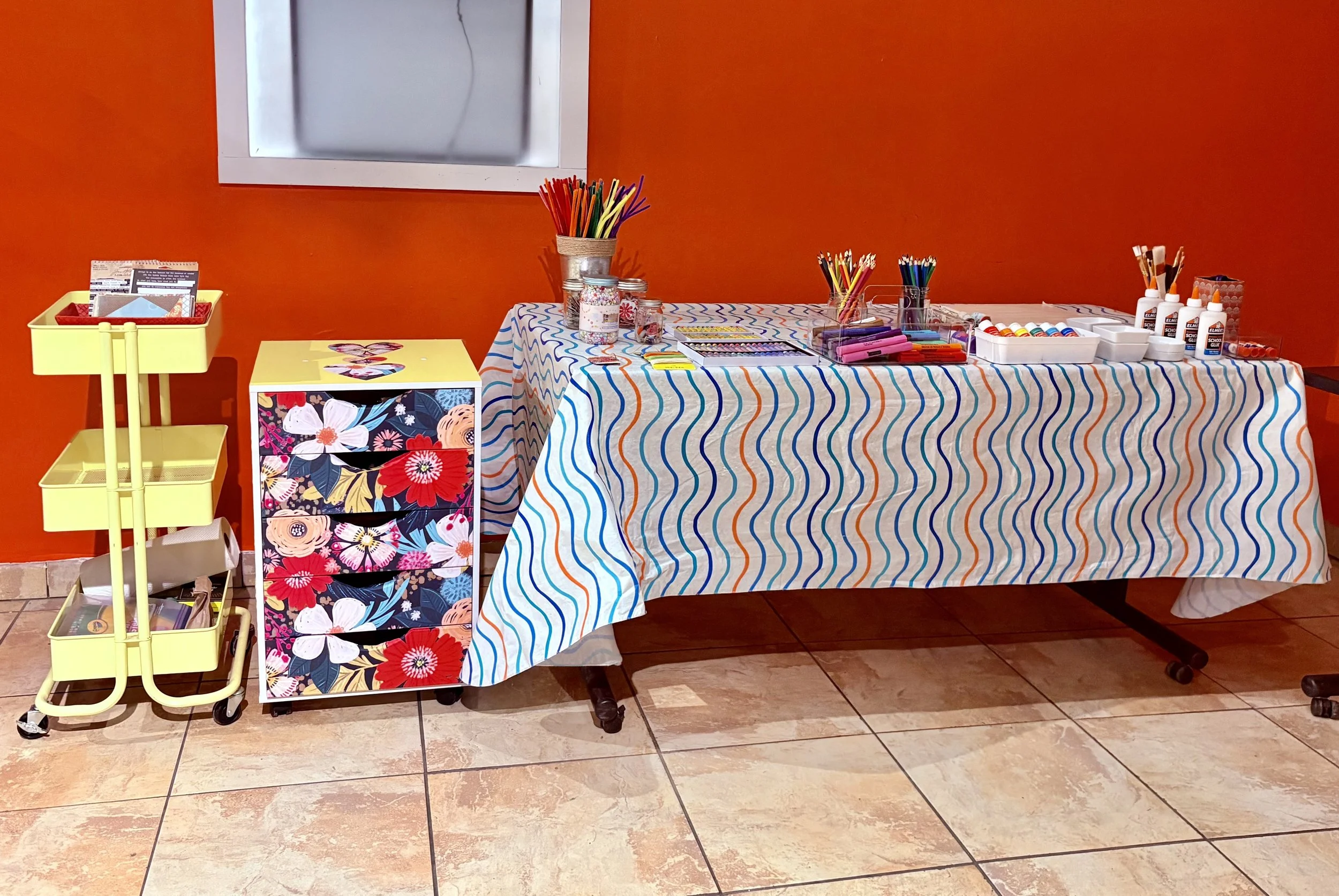Art supply table set up with pipe cleaners, paint, pencils, and glue for ArtFull Thursdays at Manitou Art Center.