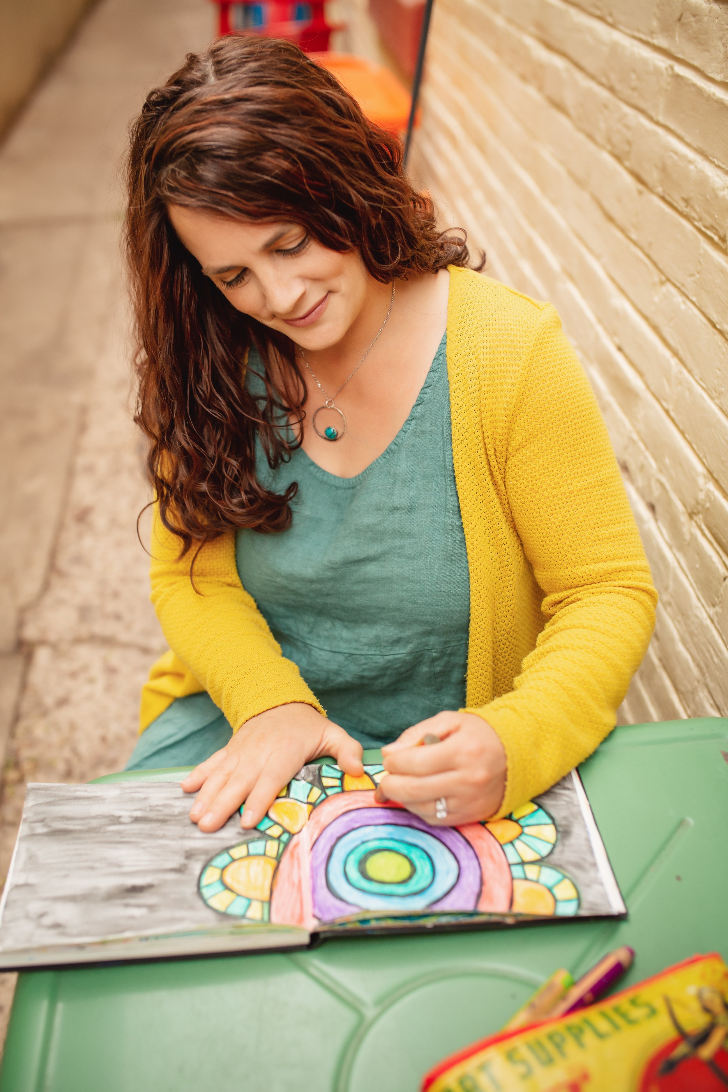 Dr. Nikki Blakesley coloring a mandala design in an art journal, facilitator of ArtFull Thursdays, a free expressive arts circle in Manitou Springs, CO.