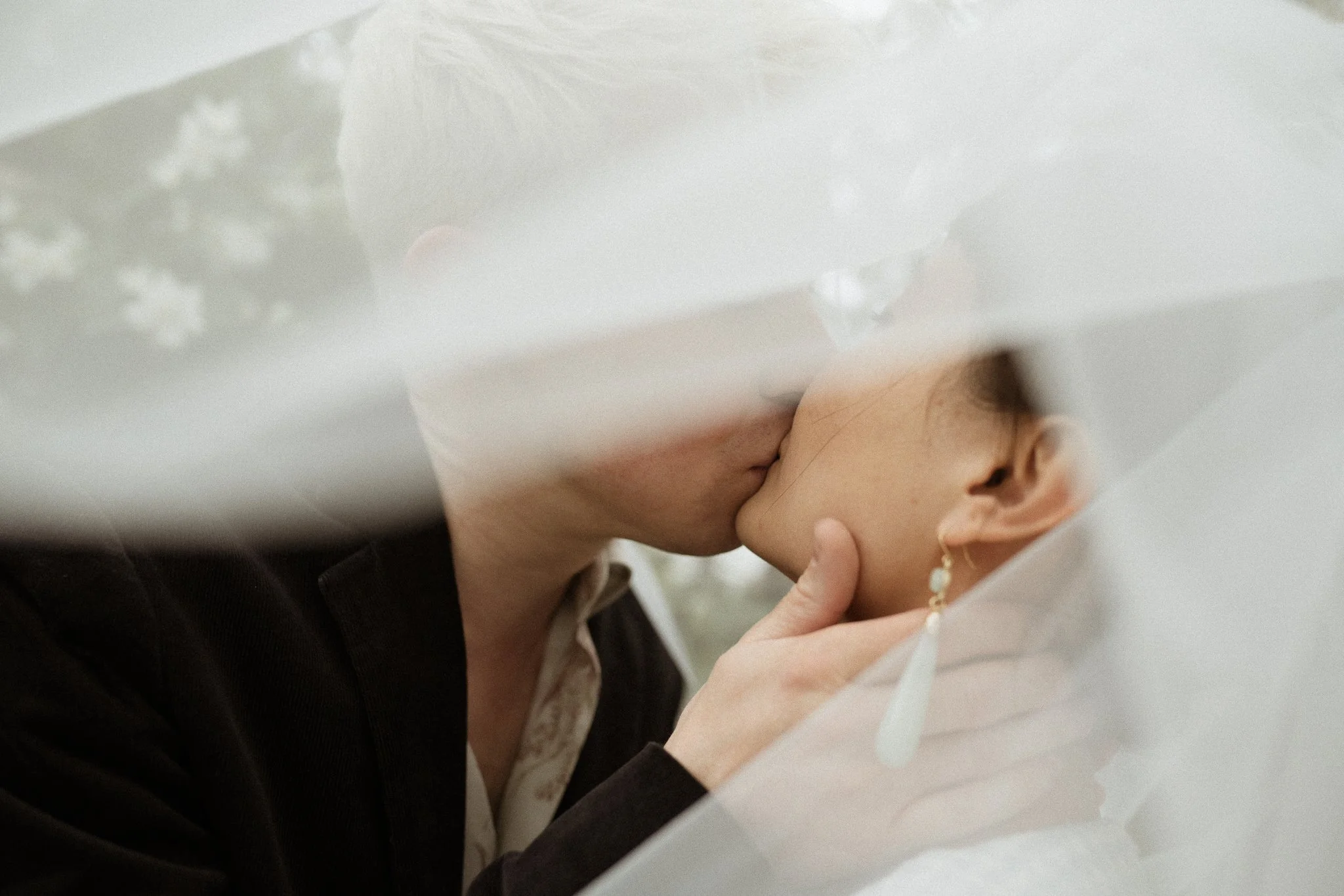 Kent wedding photography of newly weds kissing under a wedding veil
