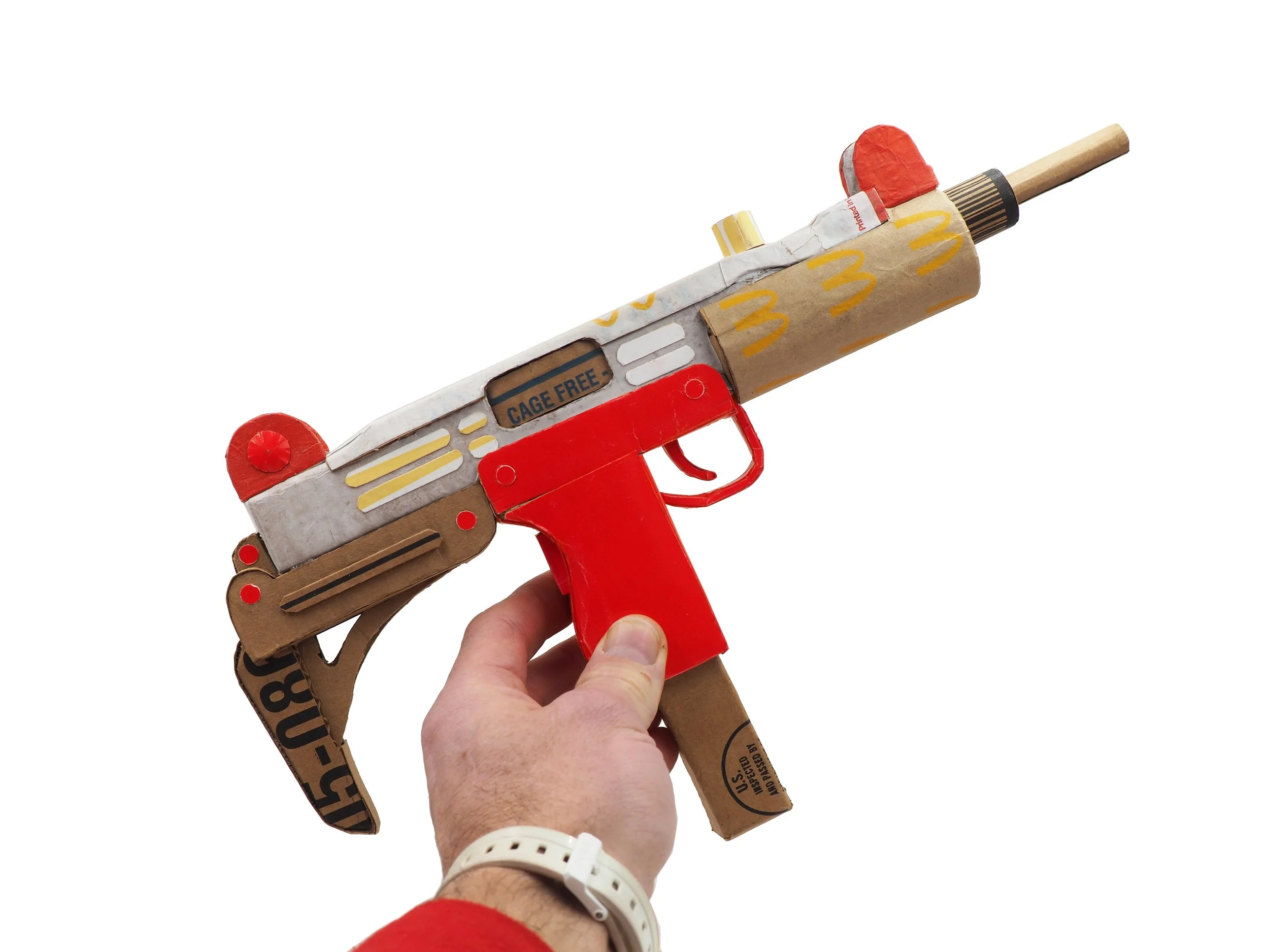 Mass shooting cardboard Uzi recycled material art sculpture political action McDonalds corporate culture parody